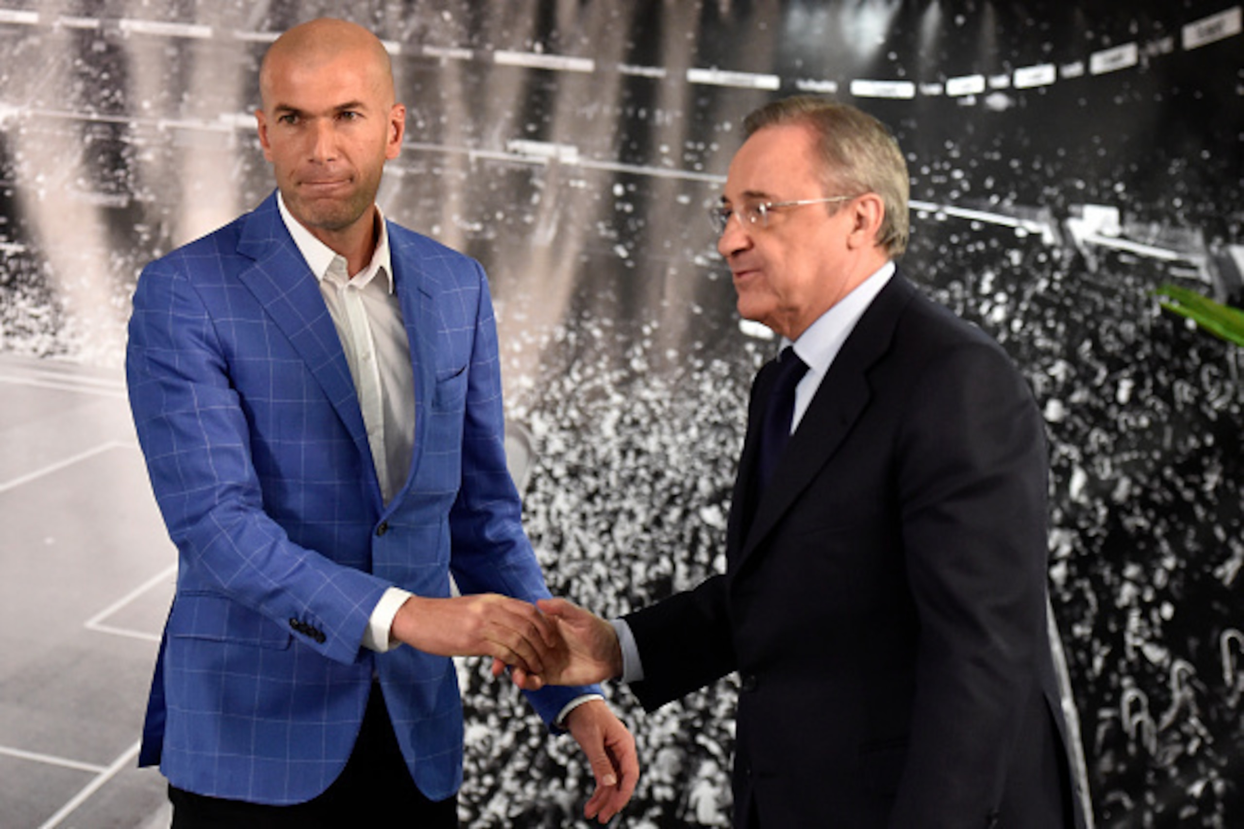 Real Madrid's new French coach Zinedine Zidane (L) is congratulated by Real Madrid's president Florentino Perez after a statement at the Santiago Bernabeu stadium in Madrid on January 4, 2016. Rafael Benitez's unhappy reign in charge of Real Madrid came t