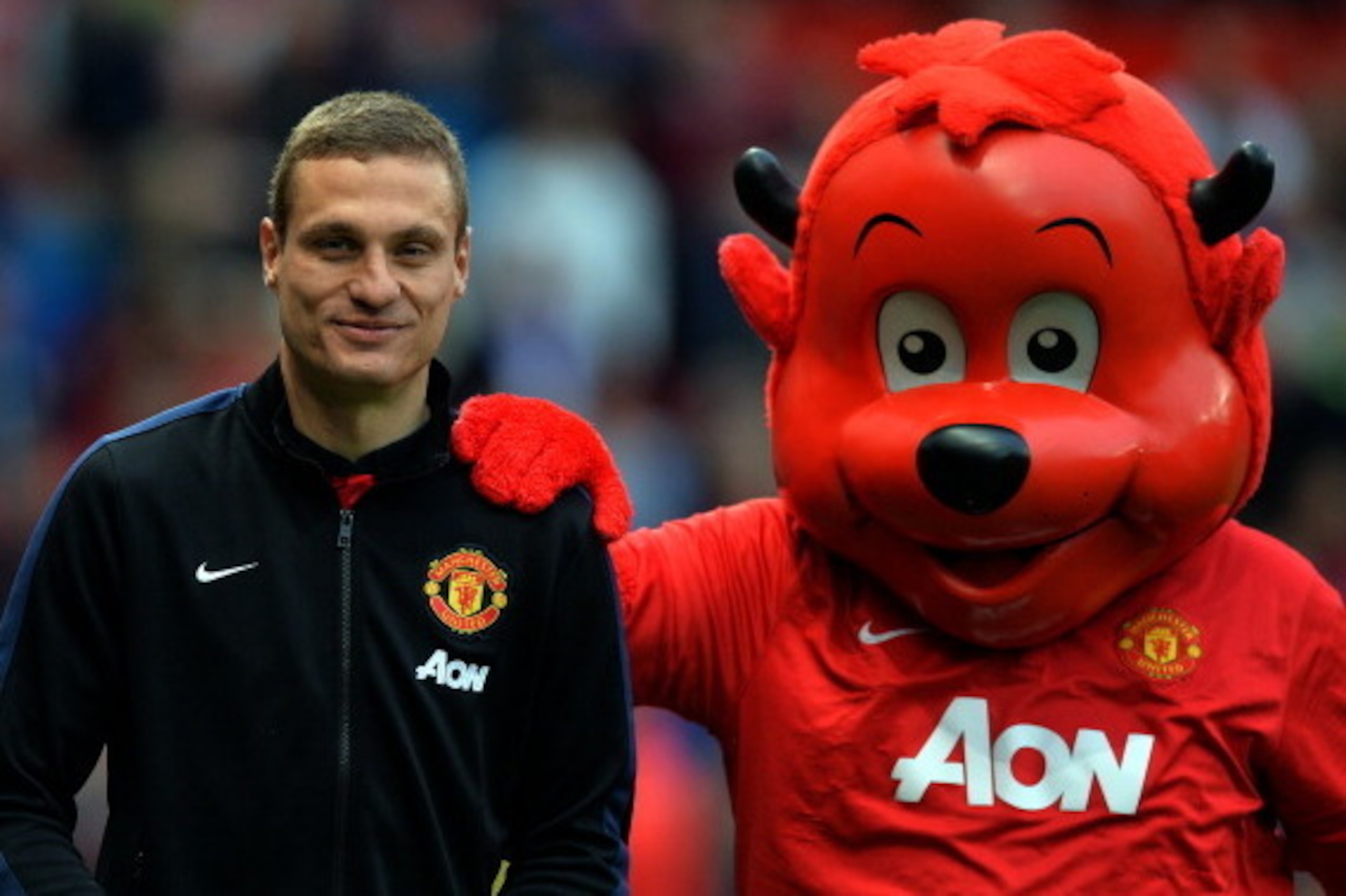 Manchester United's Serbian defender Nemanja Vidic (L) with the club mascot before the English Premier League football match between Manchester United and Hull City at Old Trafford in Manchester, northwest England on May 6, 2014. The Premier League fixtur