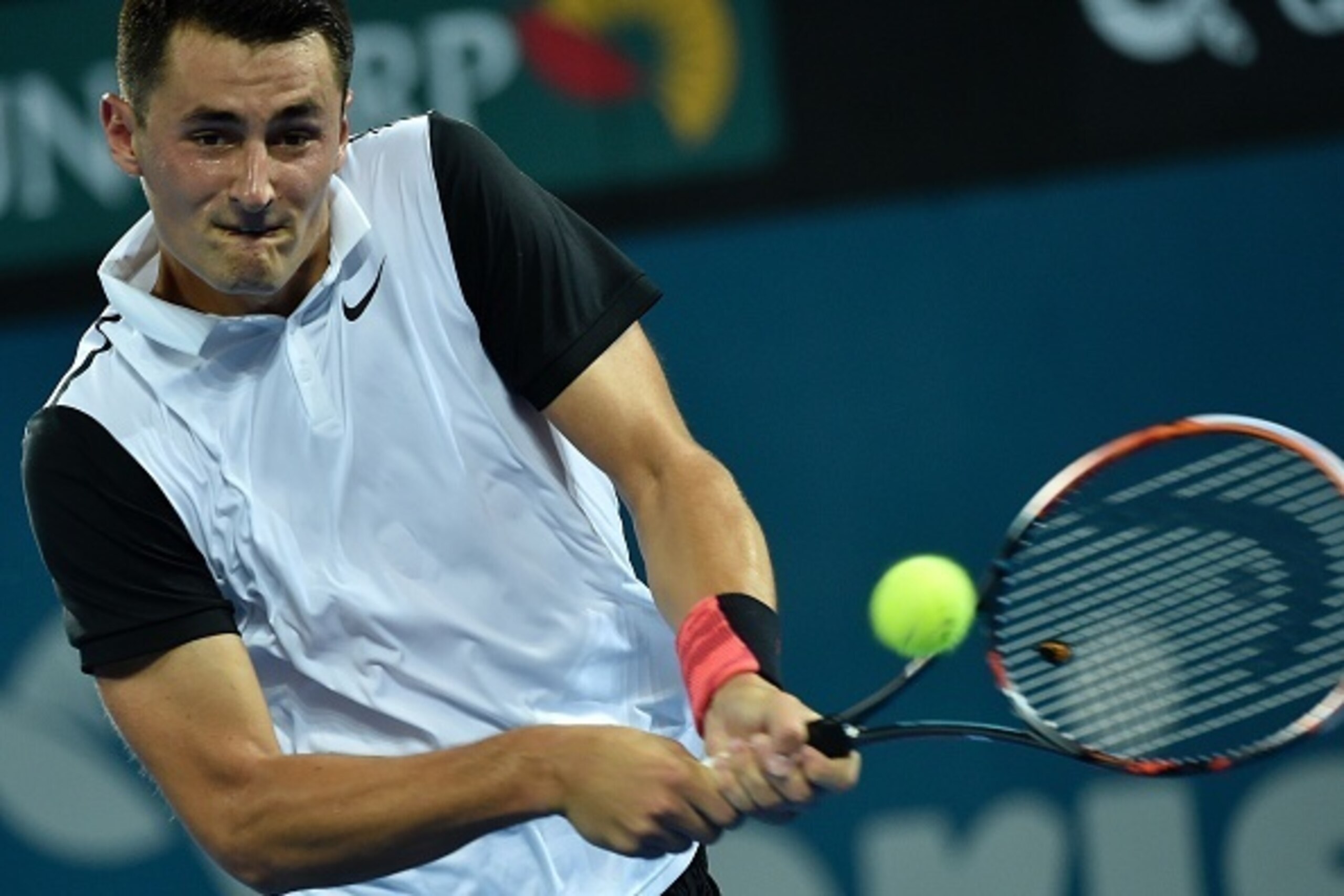 Australia's Bernard Tomic hits a return against Nicolas Mahut of France in their men's singles match on the third day at the Brisbane International tennis tournament on January 5, 2016. AFP PHOTO / Saeed KHAN
-- IMAGE RESTRICTED TO EDITORIAL USE - STRICTL