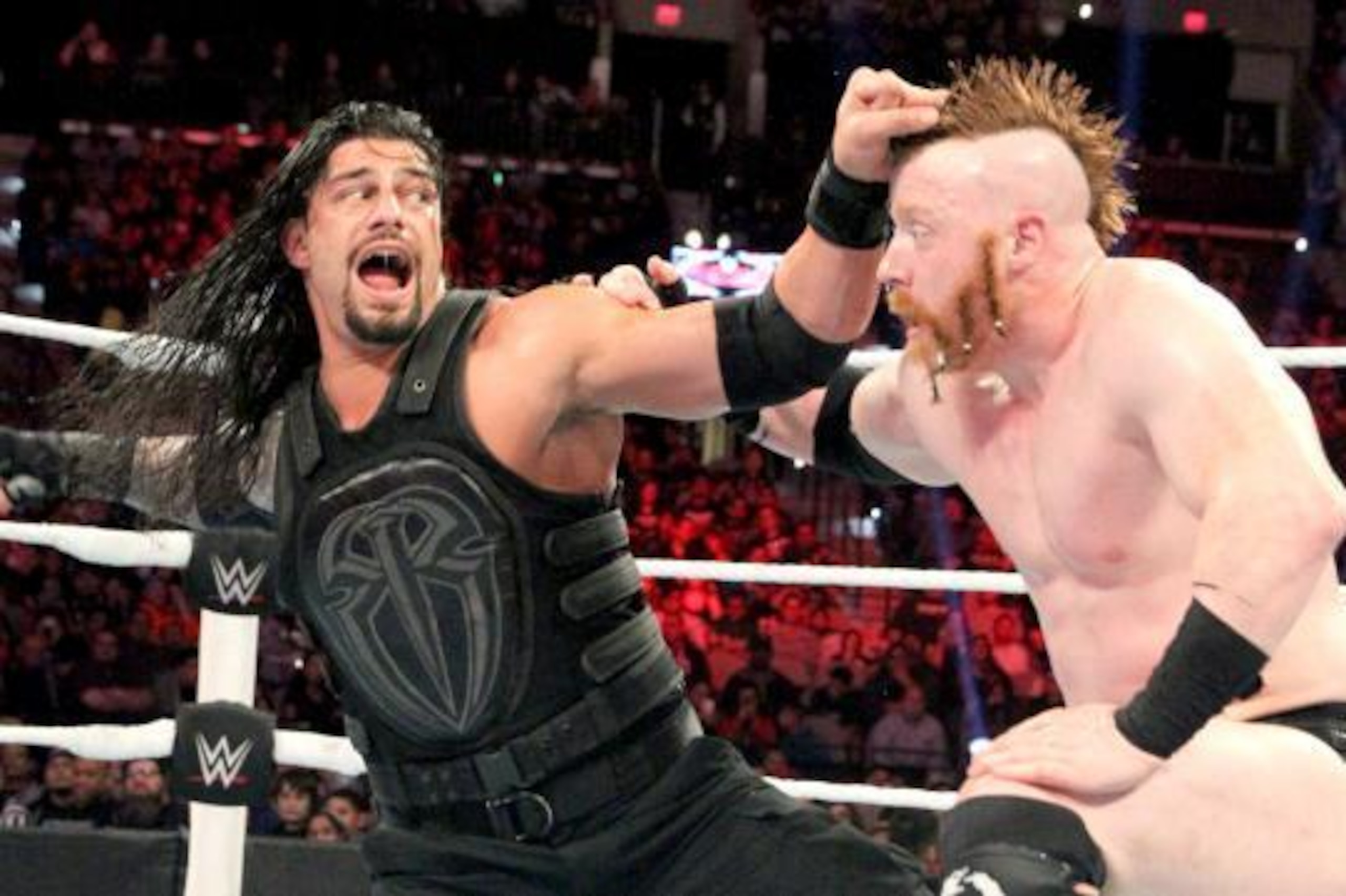 Roman Reigns measures Sheamus for a right hand.