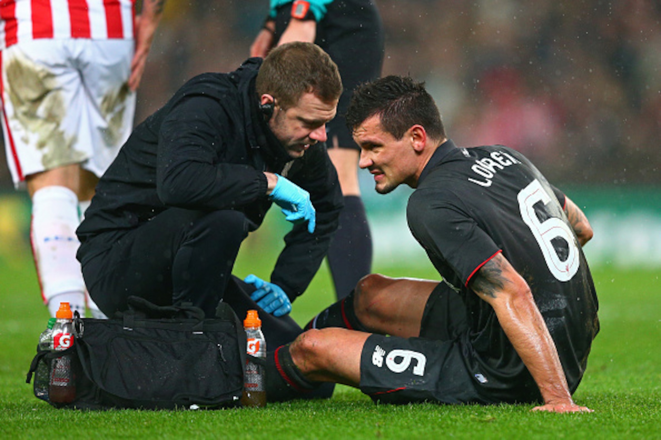 STOKE ON TRENT, ENGLAND - JANUARY 05:  Philippe Coutinho of Liverpool receives treatment before leaving the pitch due to the injury during the Capital One Cup semi final, first leg match between Stoke City and Liverpool at the Britannia Stadium on January
