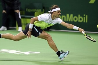 Spanish player Rafael Nadal returns the ball to his compatriot Pablo Carreno Busta in their tennis match during the Qatar Open tournament on January 5, 2016, in Doha. AFP PHOTO / KARIM JAAFAR / AFP / KARIM JAAFAR        (Photo credit should read KARIM JAA