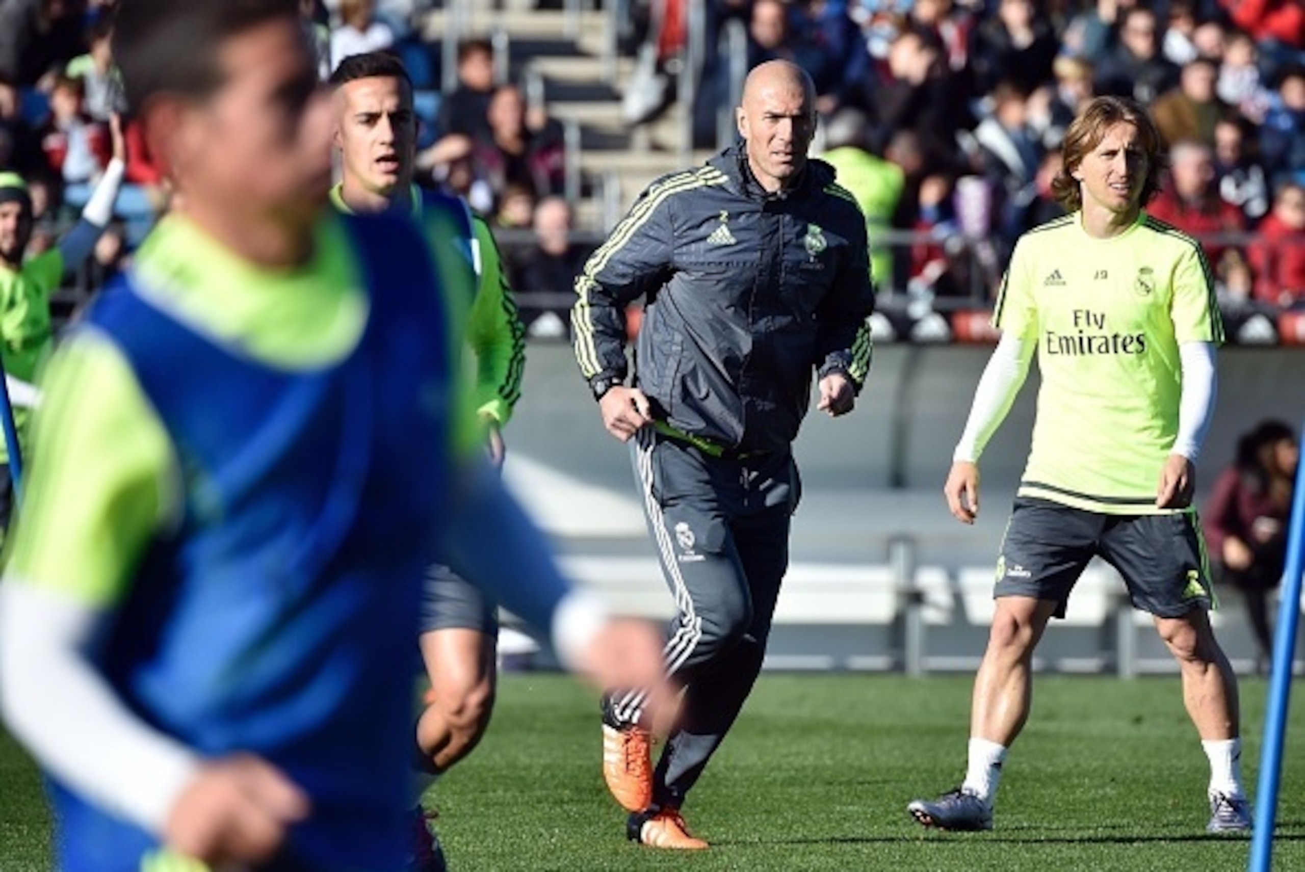 Real Madrid's new French coach Zinedine Zidane (C) runs past Real Madrid's Croatian midfielder Luka Modric (R) during his first training session as coach of Real Madrid at the Alfredo di Stefano stadium in Valdebebas, on the outskirts of Madrid, on Januar
