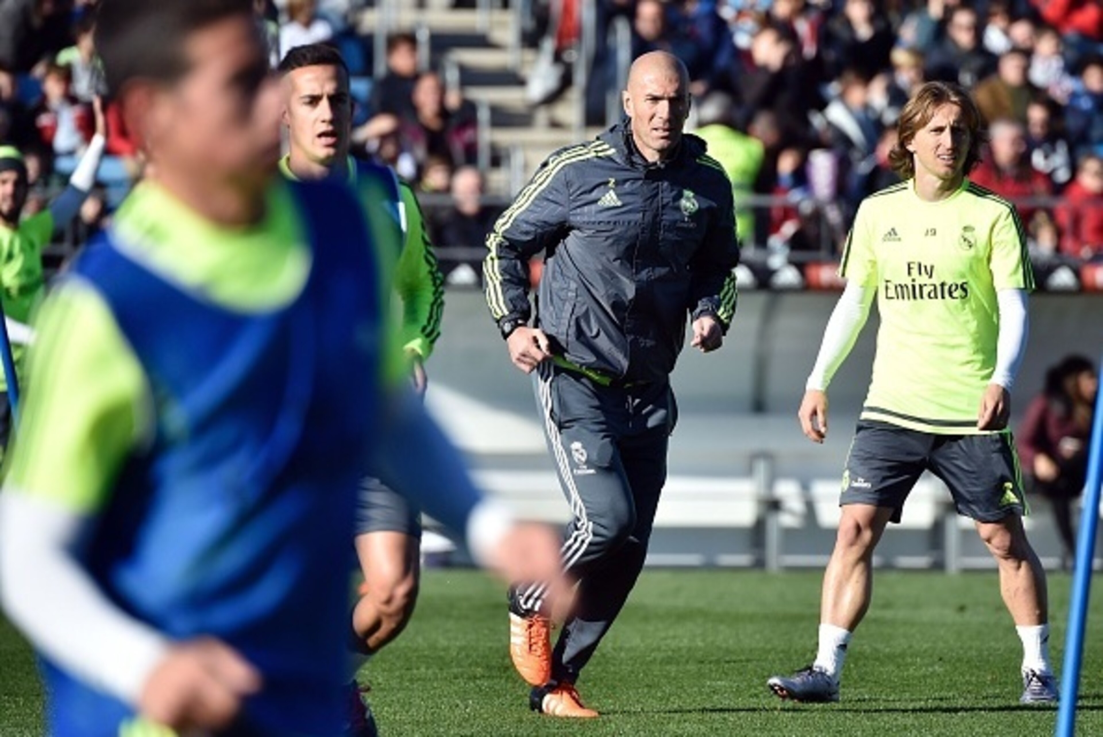 Real Madrid's new French coach Zinedine Zidane (C) runs past Real Madrid's Croatian midfielder Luka Modric (R) during his first training session as coach of Real Madrid at the Alfredo di Stefano stadium in Valdebebas, on the outskirts of Madrid, on Januar Real Madrid's new French coach Zinedine Zidane (C) runs past Real Madrid's Croatian midfielder Luka Modric (R) during his first training session as coach of Real Madrid at the Alfredo di Stefano stadium in Valdebebas, on the outskirts of Madrid, on Januar