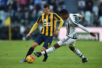 TURIN, ITALY - JANUARY 06:  Alex Sandro (R) of Juventus FC competes with Pawel Wszolek of Hellas Verona FC during the Serie A match between Juventus FC and Hellas Verona FC at Juventus Arena on January 6, 2016 in Turin, Italy.  (Photo by Valerio Pennicino