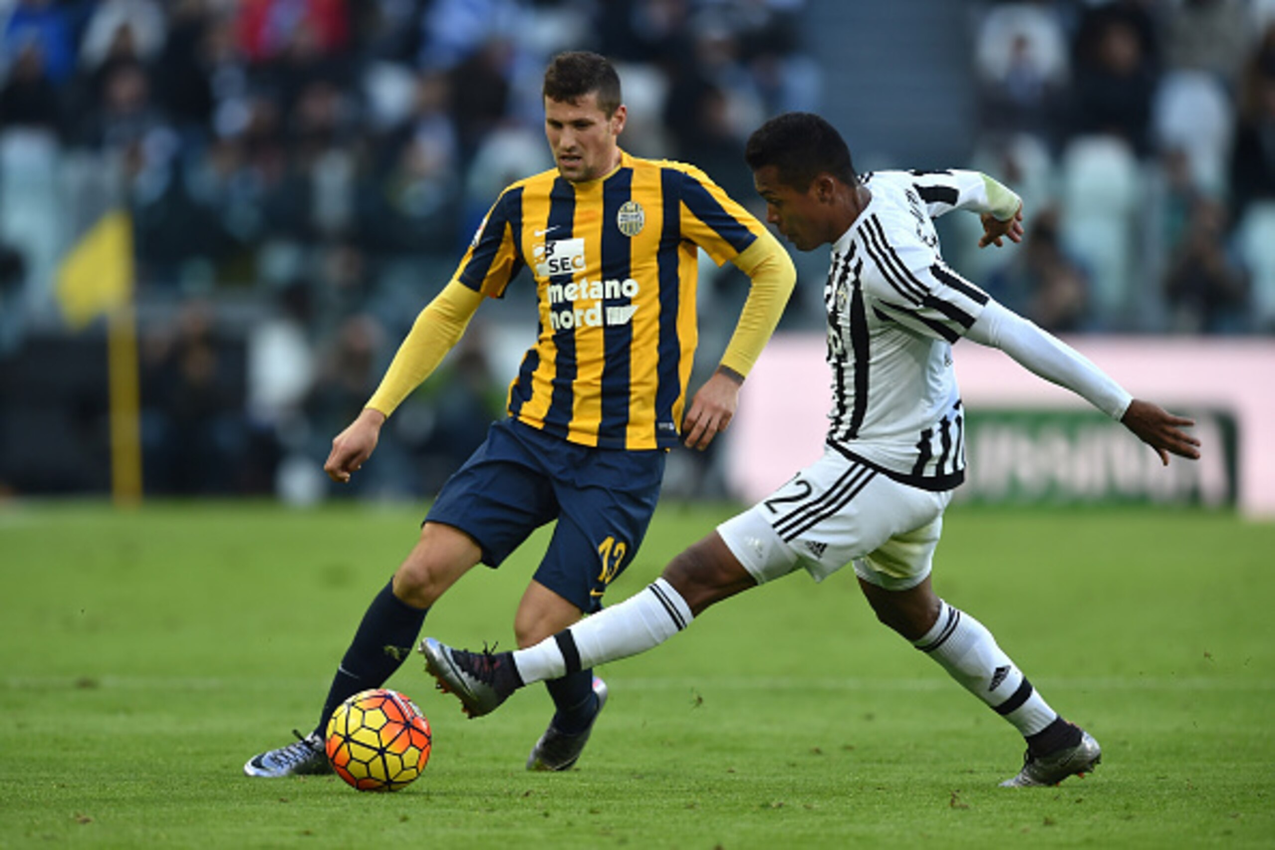 TURIN, ITALY - JANUARY 06:  Alex Sandro (R) of Juventus FC competes with Pawel Wszolek of Hellas Verona FC during the Serie A match between Juventus FC and Hellas Verona FC at Juventus Arena on January 6, 2016 in Turin, Italy.  (Photo by Valerio Pennicino