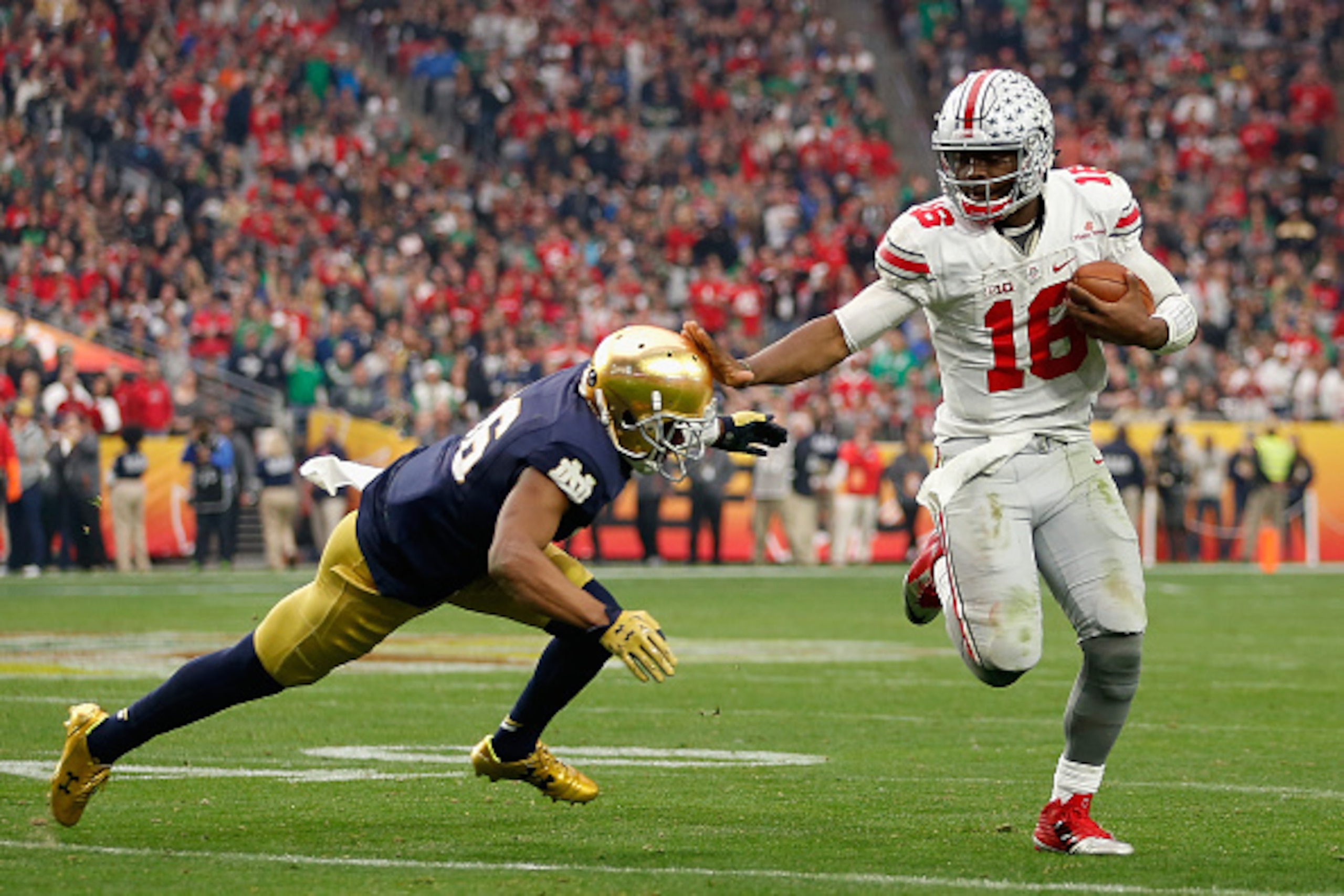 GLENDALE, AZ - JANUARY 01:  Quarterback J.T. Barrett #16 of the Ohio State Buckeyes scrambles with the football past cornerback Cole Luke #36 of the Notre Dame Fighting Irish during the BattleFrog Fiesta Bowl at University of Phoenix Stadium on January 1,
