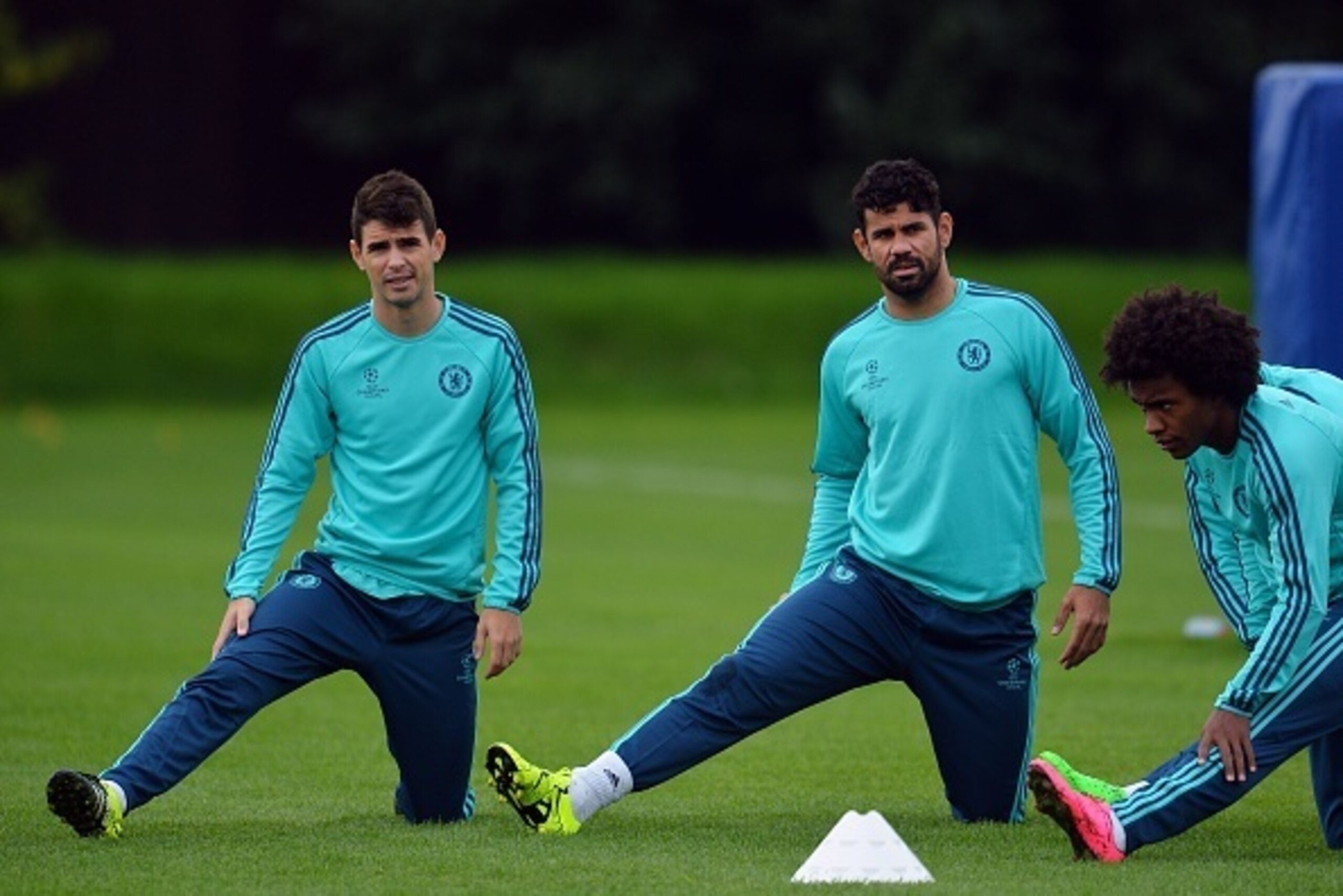 Chelsea's Brazilian midfielder Oscar (L), Spanish striker Diego Costa (C) and Brazilian midfielder Willian (R) stretch   during a training session at Chelsea's training ground, in Stoke D'Abernon, near London, on September 15, 2015, ahead of the team's fo