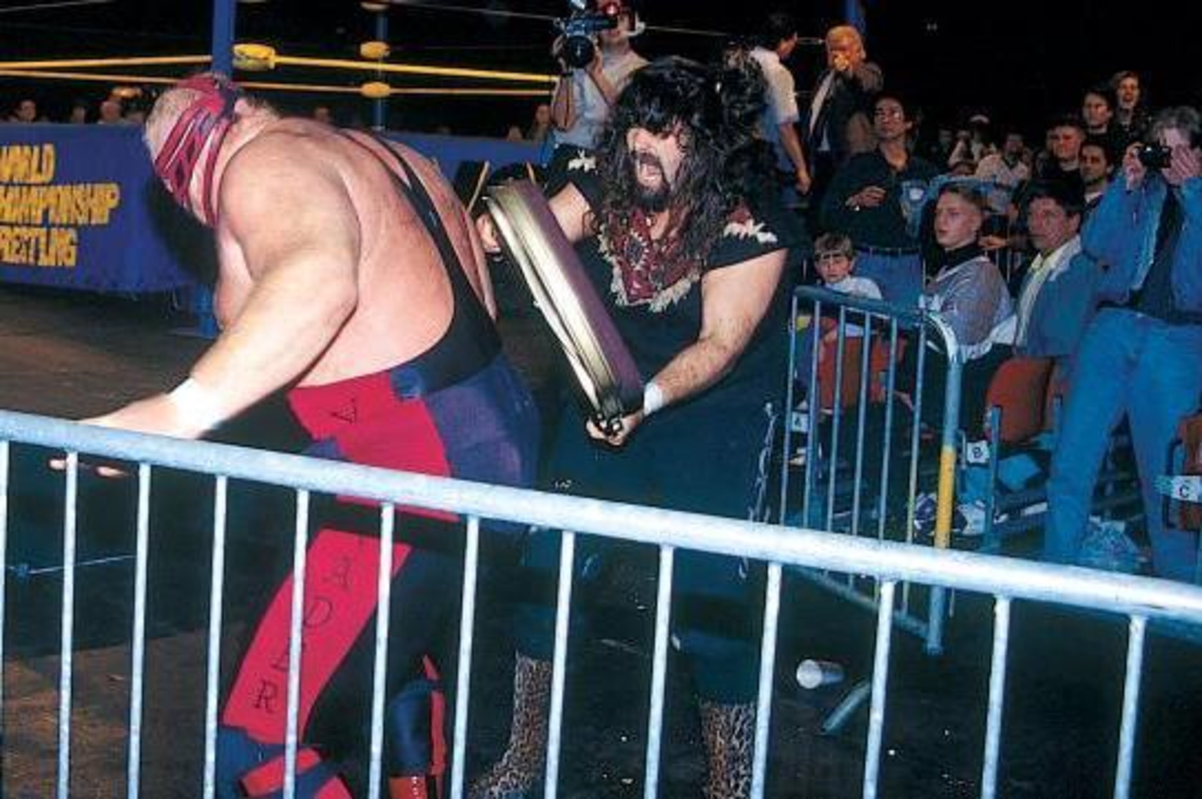 Cactus Jack attacks Vader outside the ring. Cactus Jack attacks Vader outside the ring.