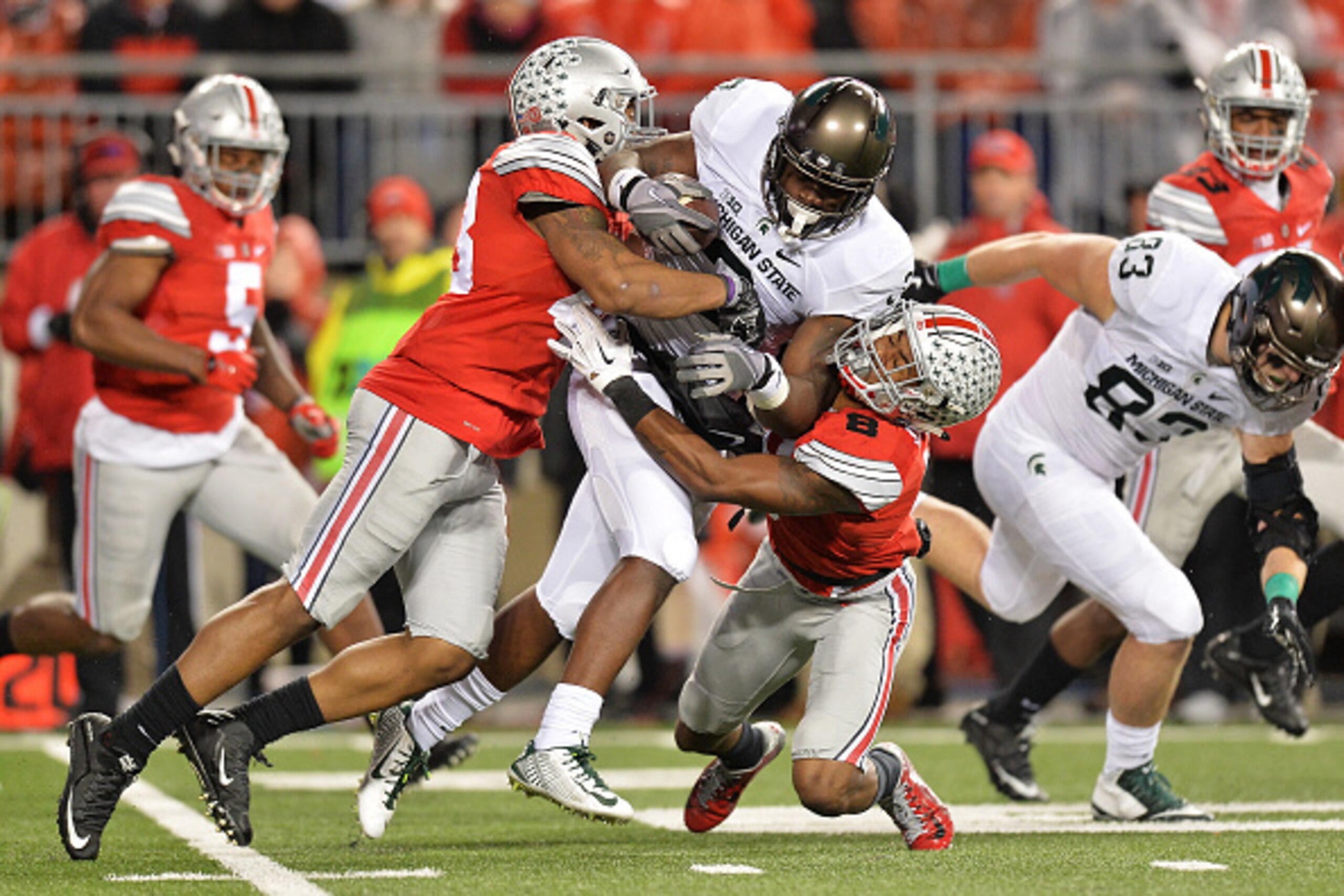 COLUMBUS, OH - NOVEMBER 21:  LJ Scott #3 of the Michigan State Spartans plows forward for a first down in the fourth quarter as Darron Lee #43 of the Ohio State Buckeyes and Gareon Conley #8 of the Ohio State Buckeyes make the tackle at Ohio Stadium on No