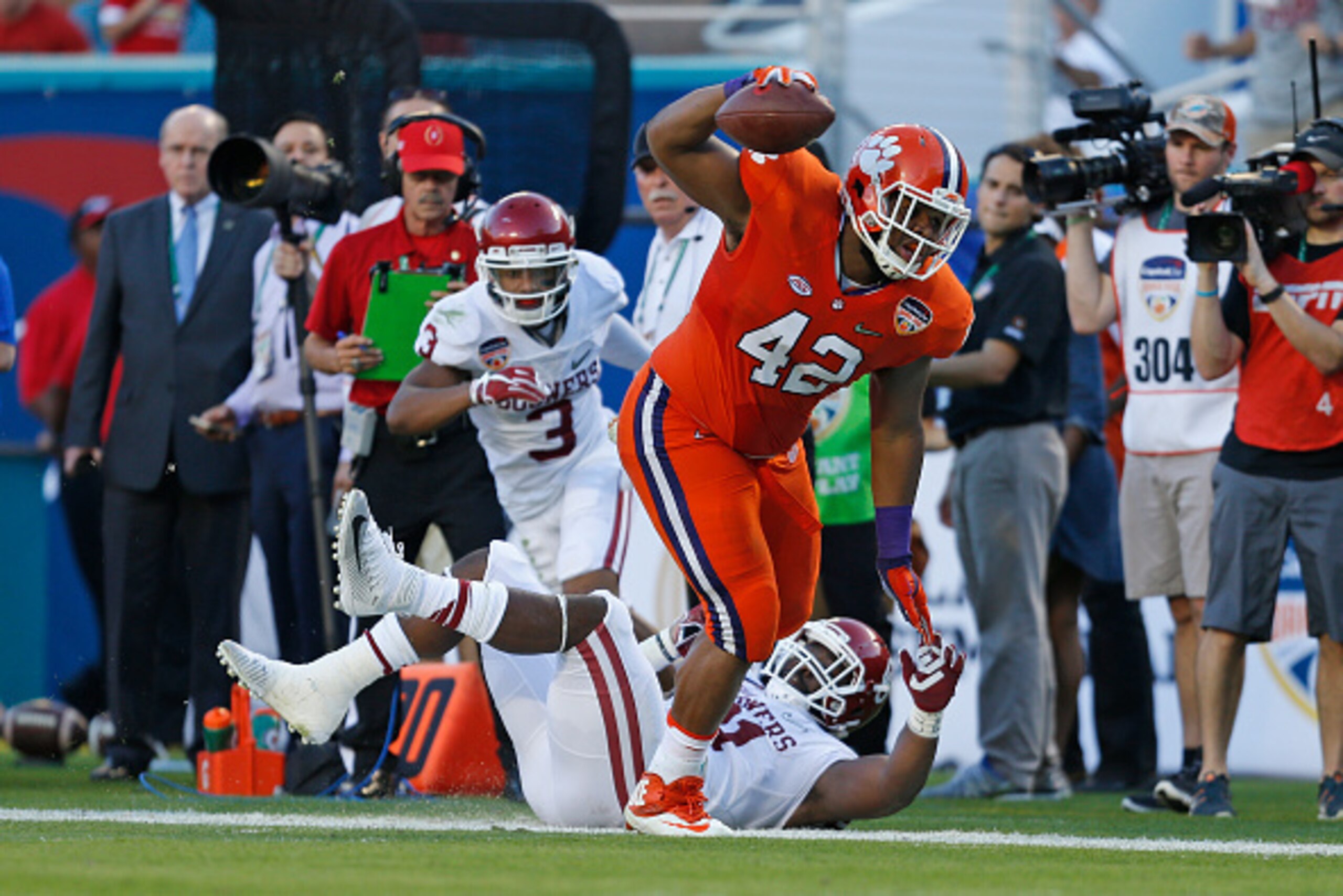 MIAMI GARDENS, FL - DECEMBER 31: Christian Wilkins #42 of the Clemson Tigers runs with the ball past Sterling Shepard #3 and Mark Andrews #81 of the Oklahoma Sooners after catching a pass on a fake punt by Andy Teasdall #32 during the 2015 Capital One Ora