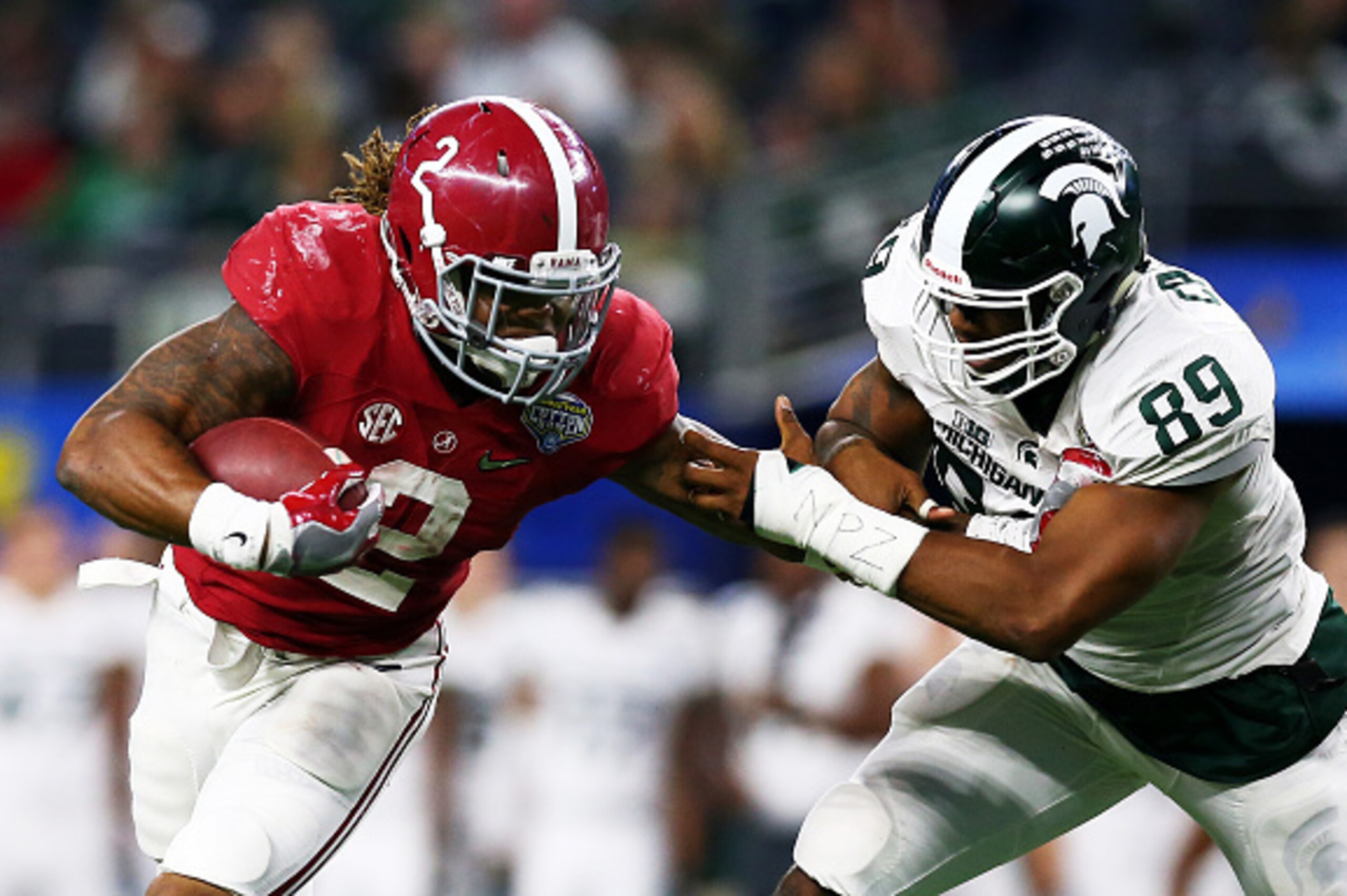 ARLINGTON, TX - DECEMBER 31:  Running back Derrick Henry #2 of the Alabama Crimson Tide stiff arms defensive end Shilique Calhoun #89 and then runs for a touchdown in the fourth quarter against the Michigan State Spartans during the Goodyear Cotton Bowl a