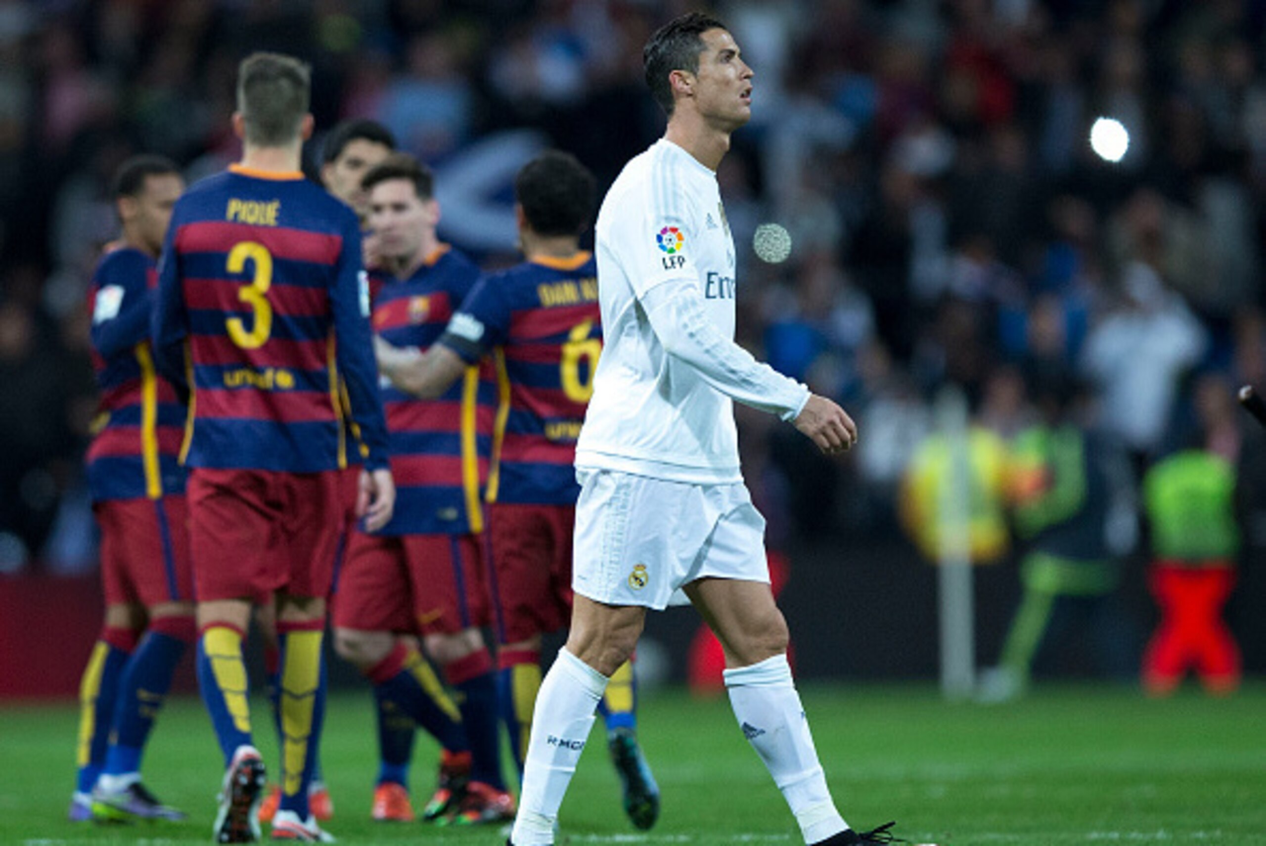 MADRID, SPAIN - NOVEMBER 21:  Cristiano Ronaldo of Real Madrid CF leaves the pithc as FC Barcelona players celebrate their victory after the La Liga match between Real Madrid CF and FC Barcelona at Estadio Santiago Bernabeu on November 21, 2015 in Madrid,