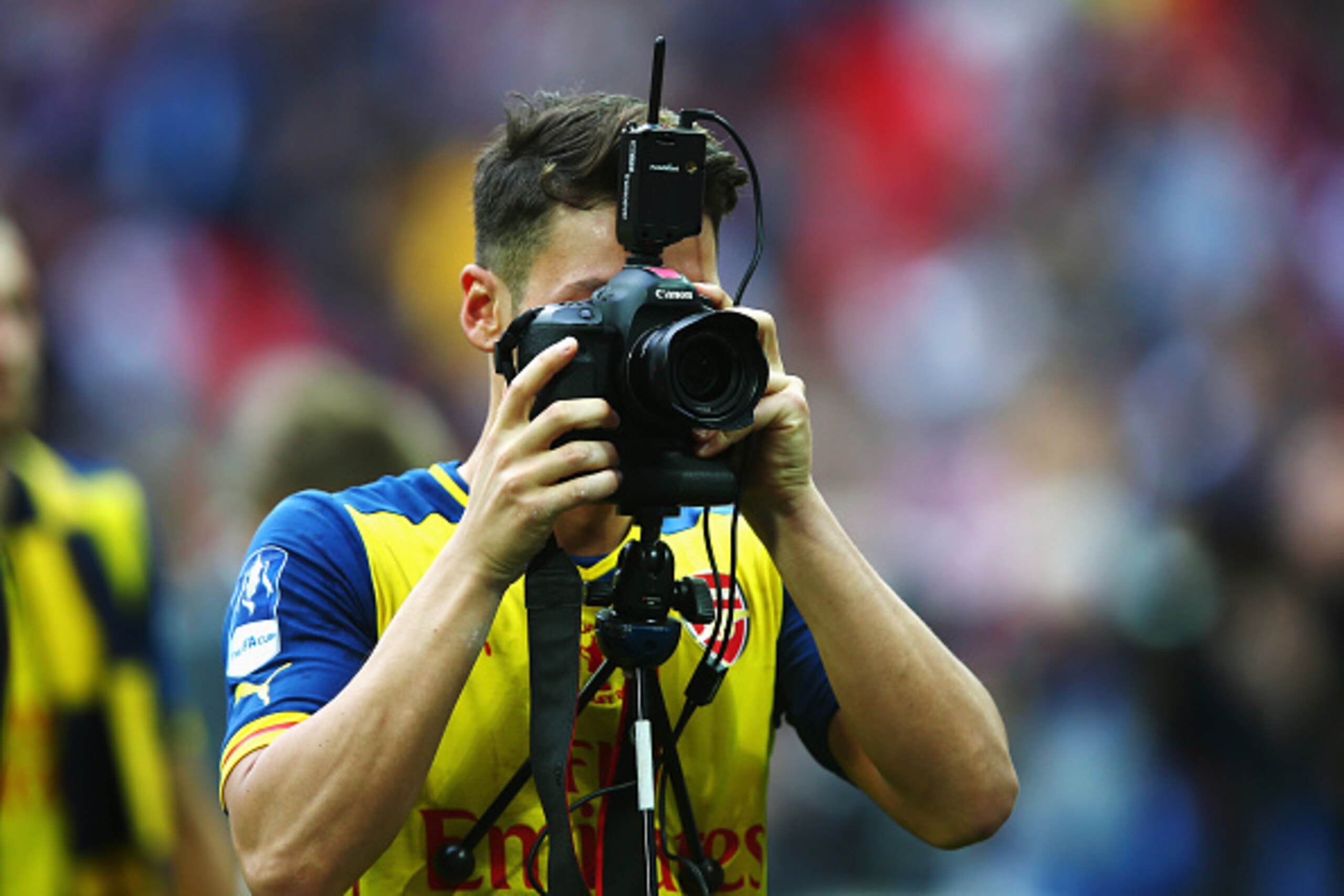 LONDON, ENGLAND - MAY 30:  Mesut Oezil of Arsenal uses a photographers camera as he celebrates victory after the FA Cup Final between Aston Villa and Arsenal at Wembley Stadium on May 30, 2015 in London, England. Arsenal beat Aston Villa 4-0.  (Photo by C