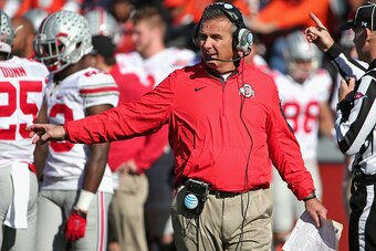 CHAMPAIGN, IL - NOVEMBER 14:  Head coach Urban Meyer of the Ohio State Buckeyes talks on his headset as his team takes on the Illinois Fighting Illini at Memorial Stadium on November 14, 2015 in Champaign, Illinois.  (Photo by Jonathan Daniel/Getty Images