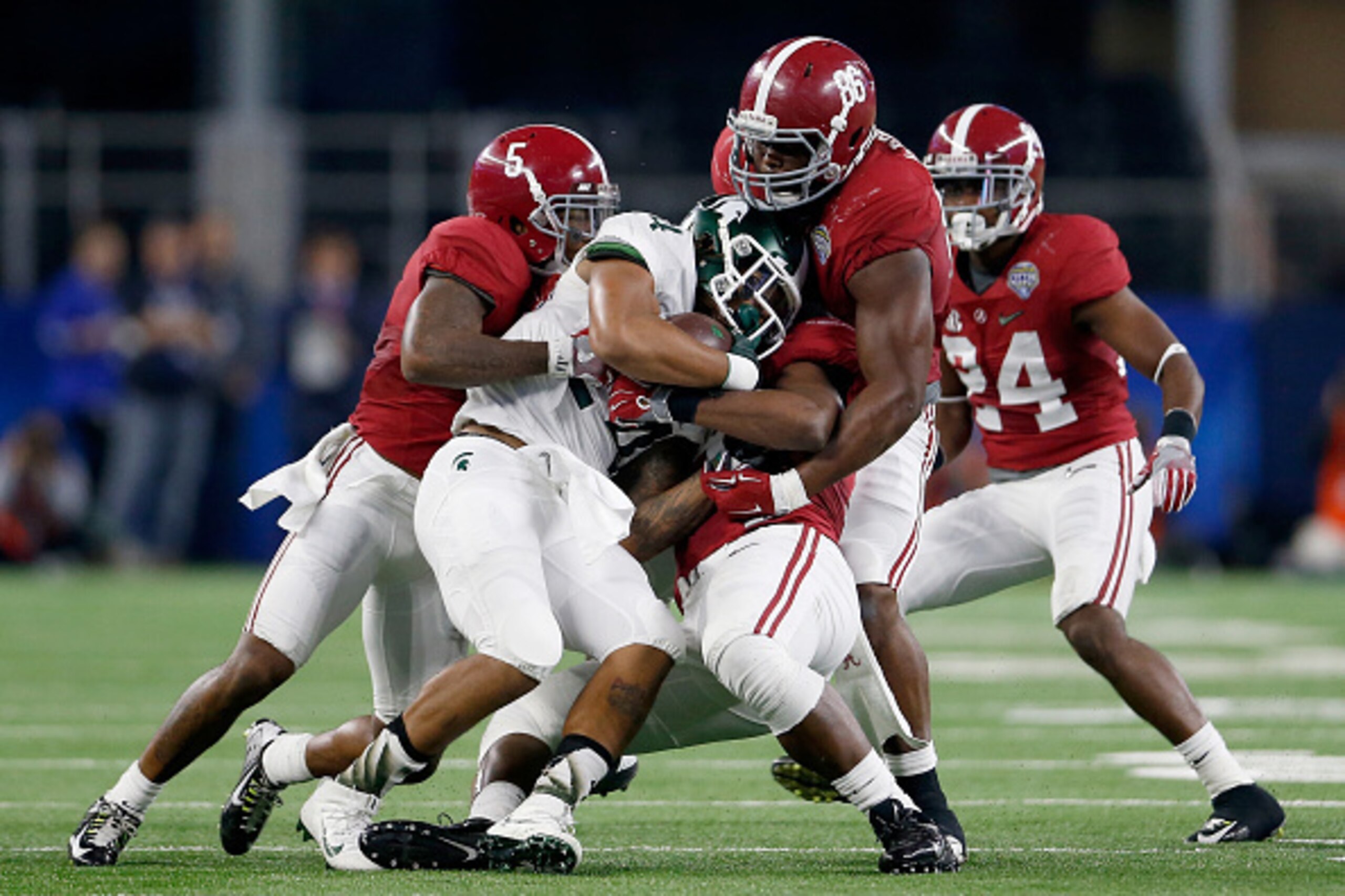 ARLINGTON, TX - DECEMBER 31:  Running back Gerald Holmes #24 of the Michigan State Spartans is tackled by defensive lineman A'Shawn Robinson #86 and Cyrus Jones #5 of the Alabama Crimson Tide during the Goodyear Cotton Bowl at AT&T Stadium on December 31,