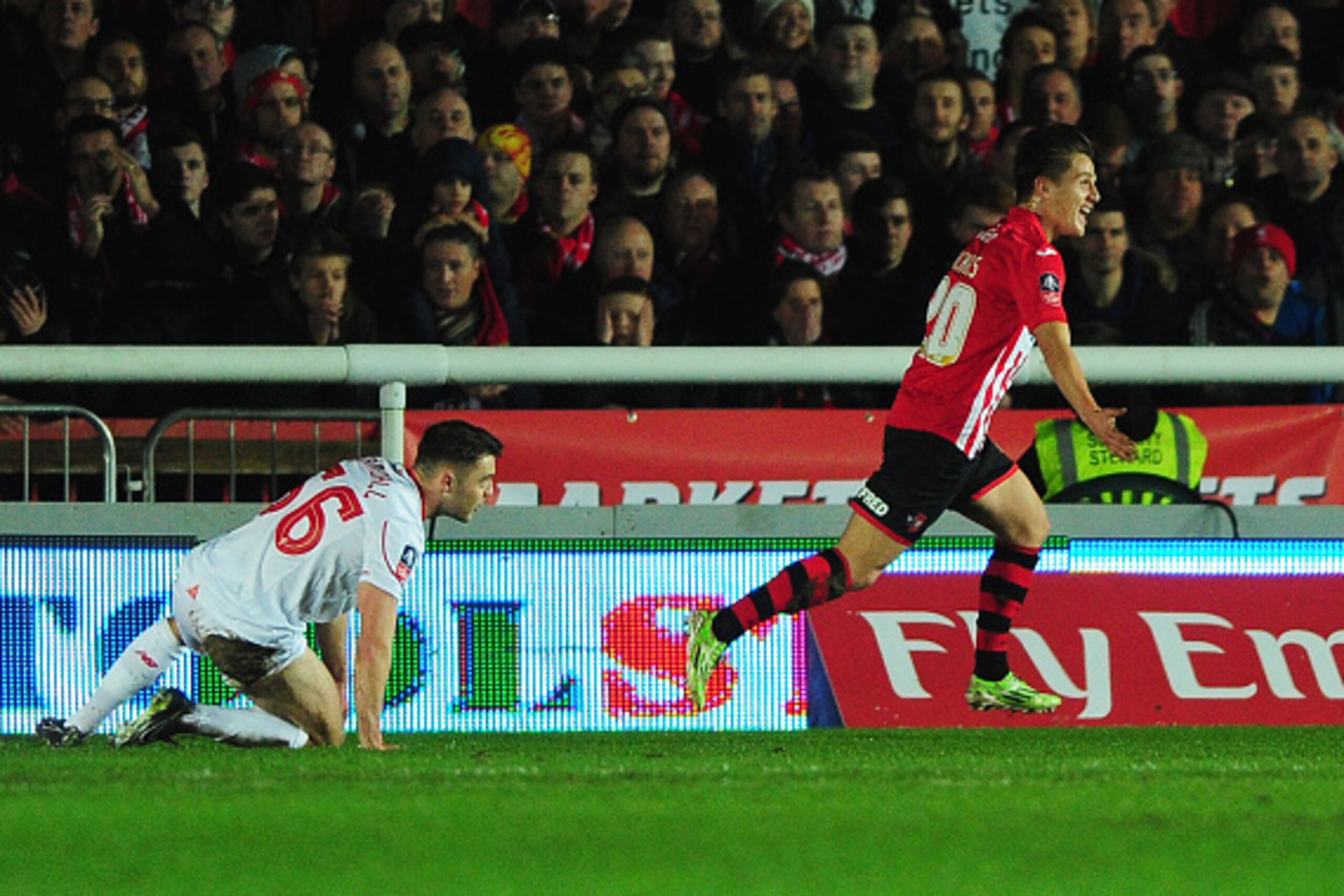EXETER, ENGLAND - JANUARY 08:  Connor Randall of Liverpool looks dejected as Tom Nichols of Exeter City celebrates scoring their opening goal during the Emirates FA Cup third round match between Exeter City and Liverpool at St James Park on January 8, 201