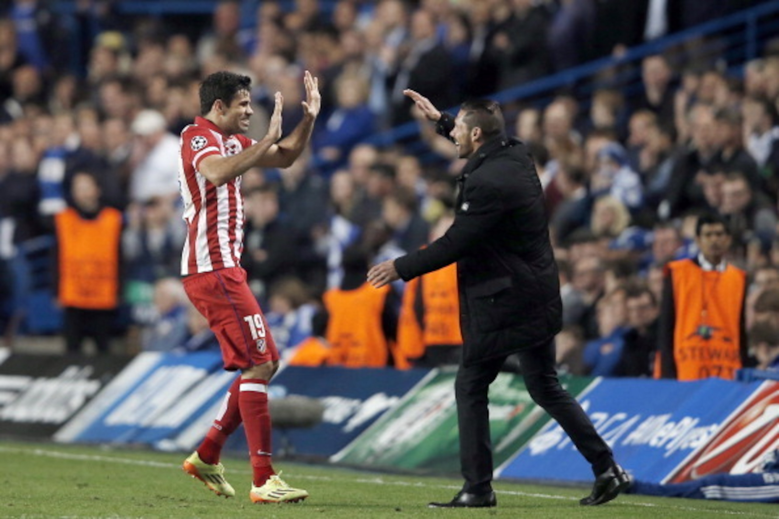 Atletico Madrid's Brazilian-born forward Diego da Silva Costa (L) celebrates scoring his team's second goal with Atletico Madrid's Argentinian coach Diego Simeone during the UEFA Champions League semi-final second leg football match between Chelsea and At