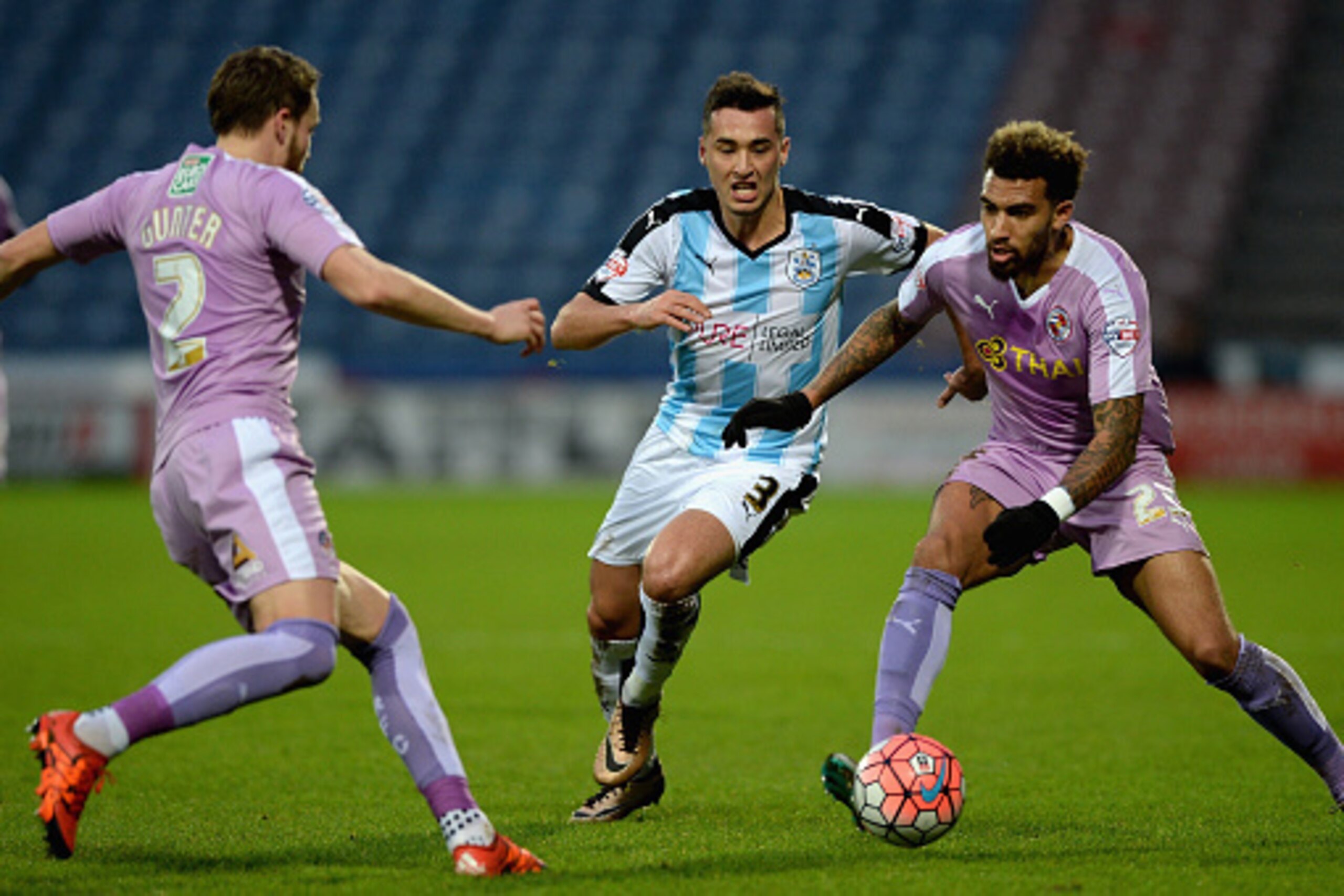 HUDDERSFIELD, ENGLAND - JANUARY 09:  Jason Davidson of Huddersfield Town looks to get past Chris Gunter and Danny Williams of Reading during The Emirates FA Cup Third Round between Huddersfield Town and Reading at John Smiths Stadium on January 9, 2016 in
