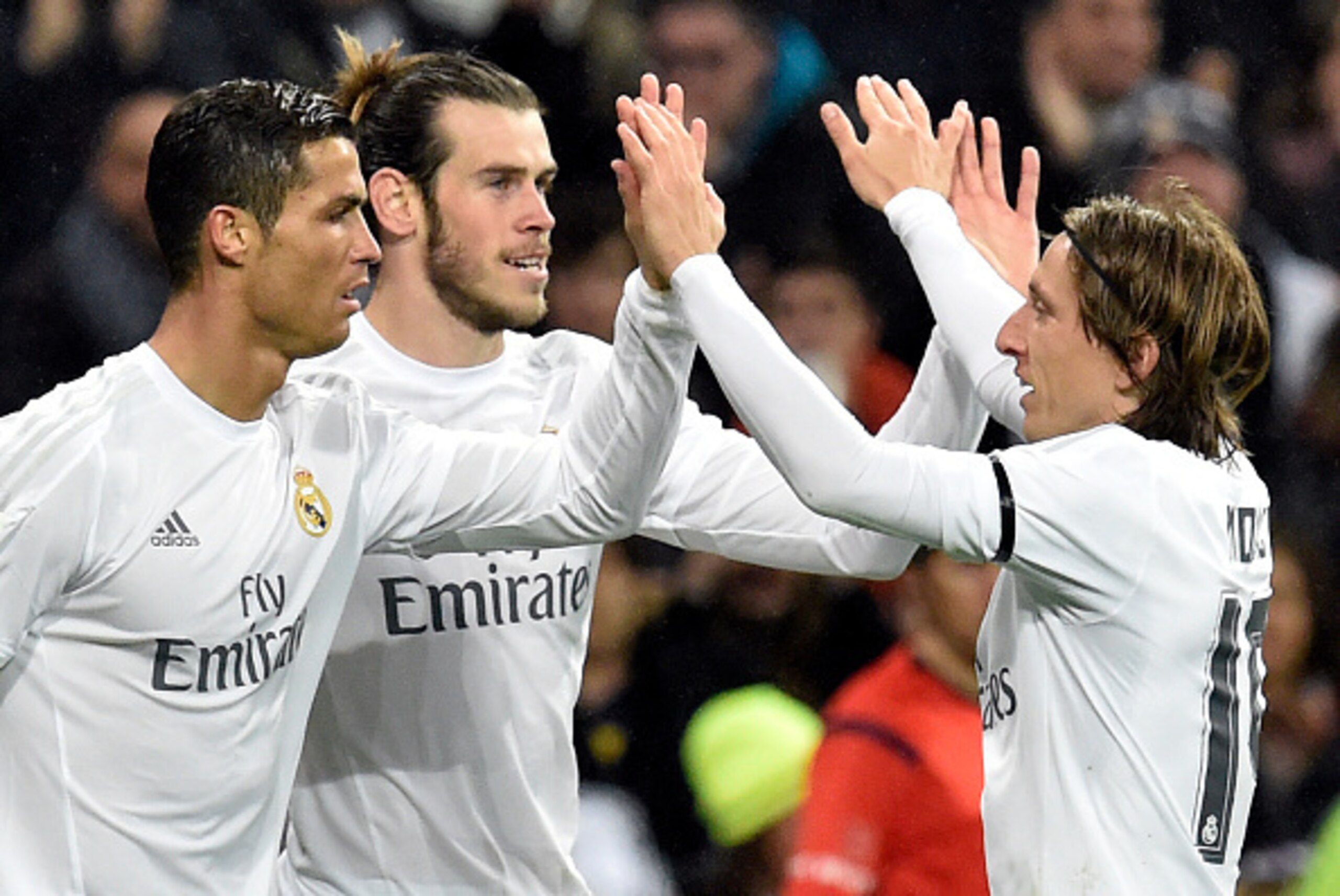 Real Madrid's Welsh forward Gareth Bale (C) is congratulated by Real Madrid's Portuguese forward Cristiano Ronaldo (L) and Real Madrid's Croatian midfielder Luka Modric after scoring during the Spanish league football match Real Madrid CF vs RC Deportivo 