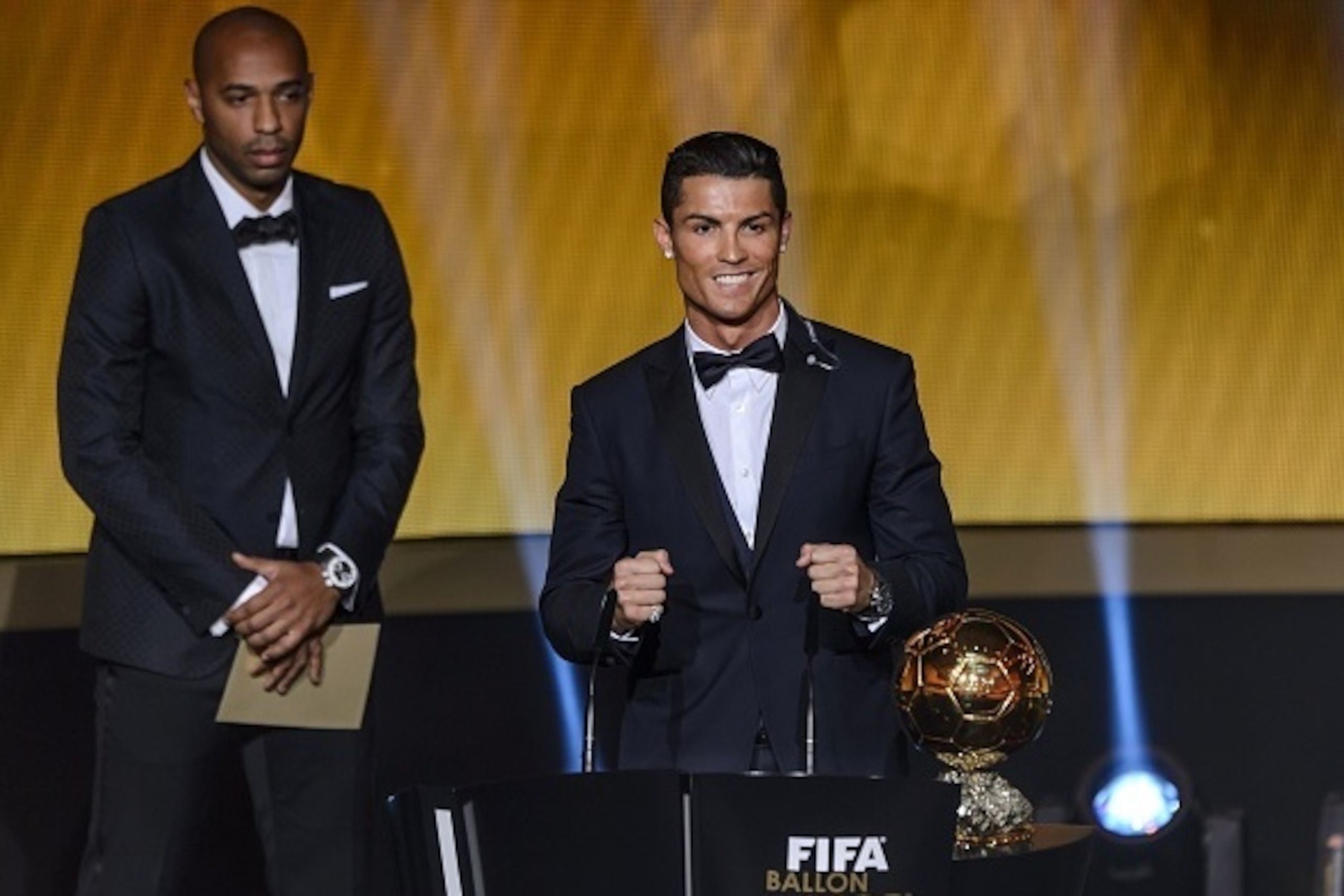Real Madrid and Portugal forward Cristiano Ronaldo (R) reacts next to French former star player Thierry Henry (L) after receiving the 2014 FIFA Ballon d'Or award for player of the year during the FIFA Ballon d'Or award ceremony at the Kongresshaus in Zuri