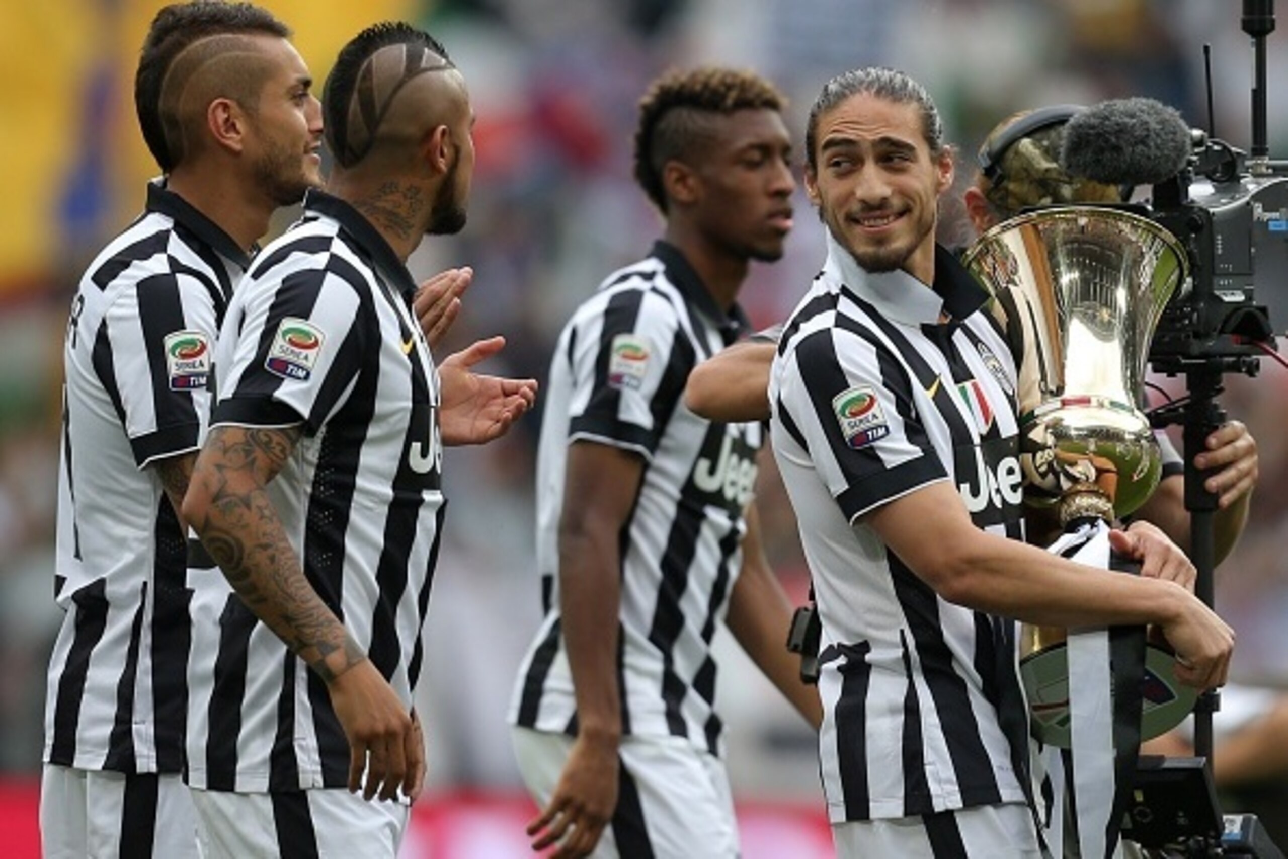 Juventus' defender from Uruguay Martin Caceres (R) holds the Cup as players present the Tim Cup trophy (Coppa Italia) to their fans prior the Italian Serie A football match Juventus vs Napoli on May 23, 2015 at the Juventus stadium in Turin. Juventus won 