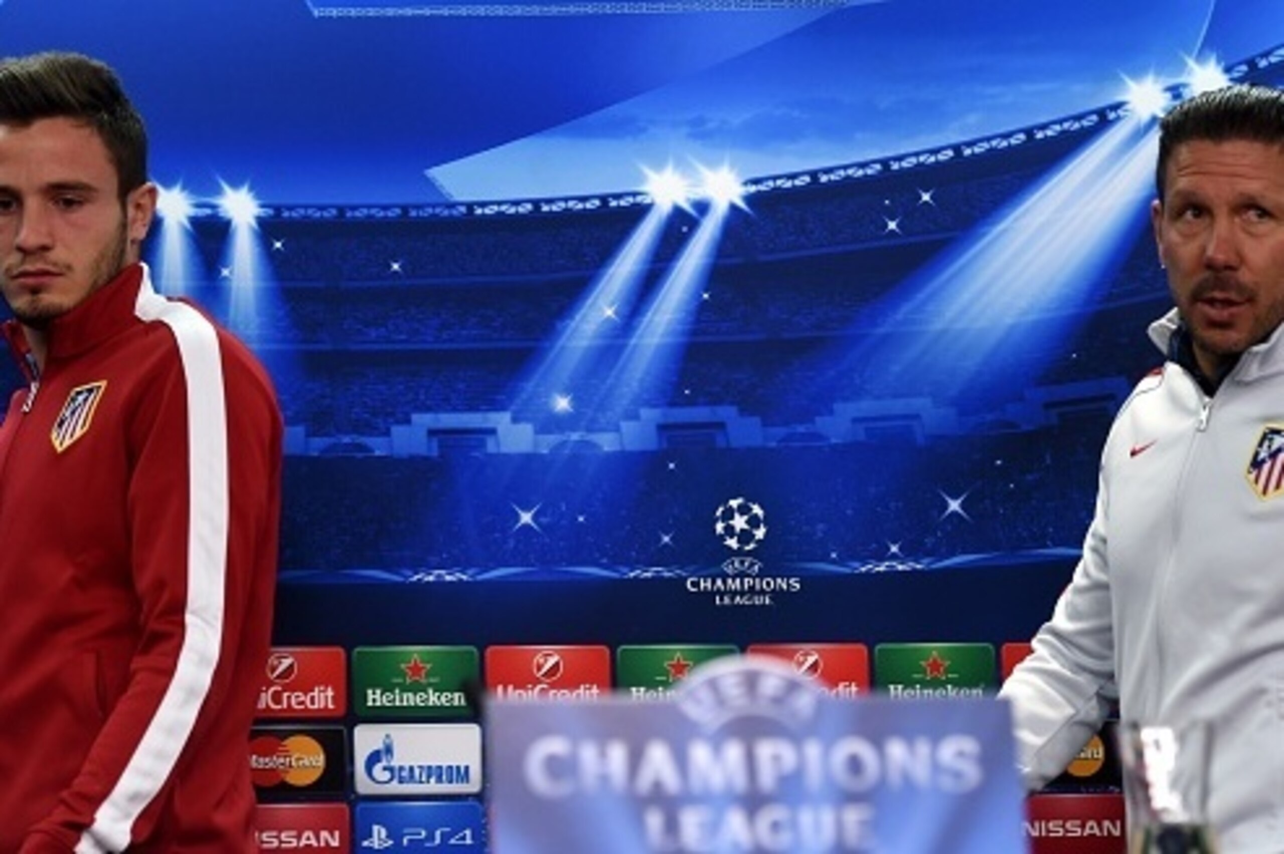 Atletico Madrid's Argentinian coach Diego Simeone (R) and midfielder Saul Niguez arrive to address a press conference on the eve of the UEFA Champions League first-leg, round of 16 football match Bayer 04 Leverkusen vs Club Atletico de Madrid in Leverkuse