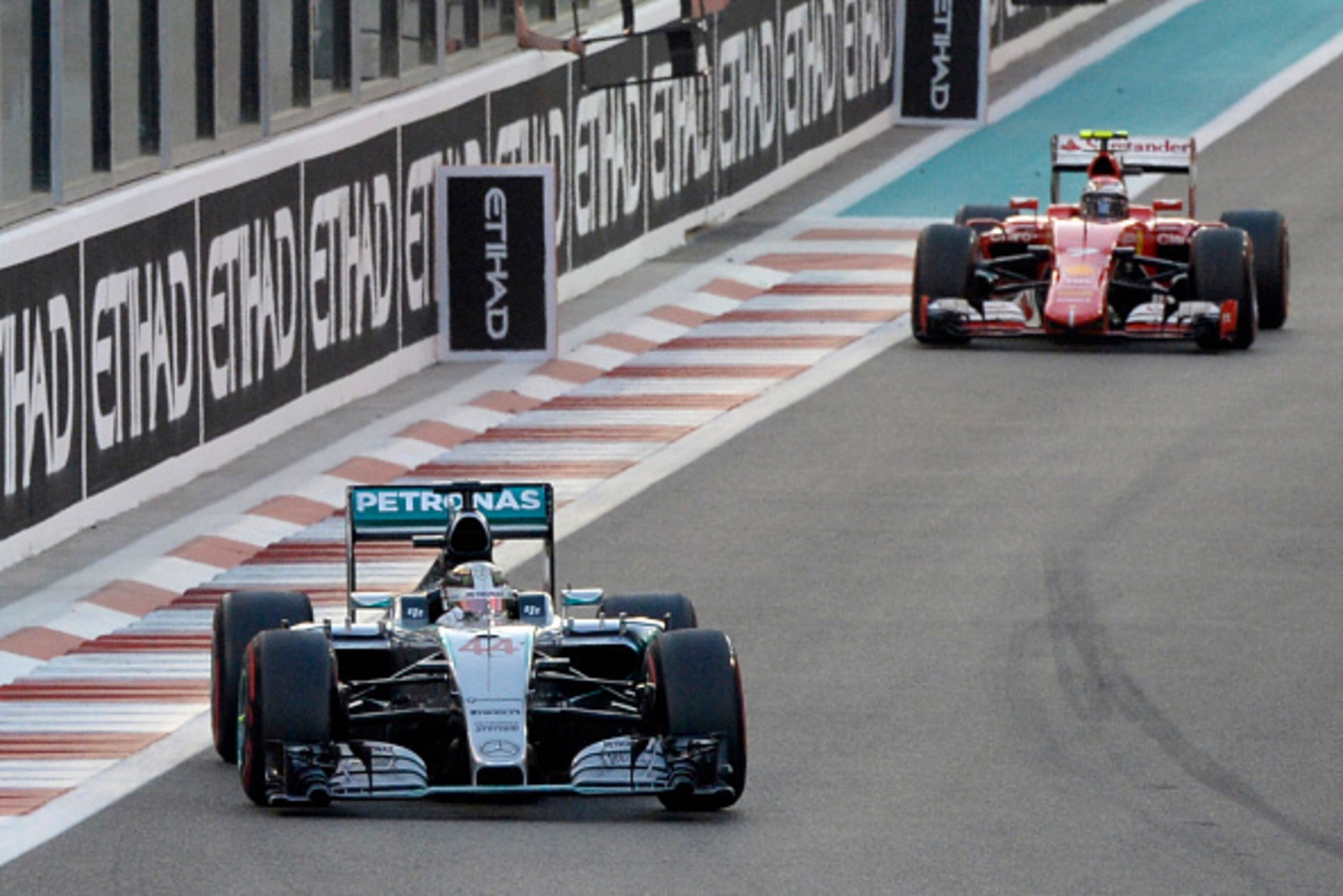 ( FROM L) Mercedes AMG Petronas F1 Team's British driver Lewis Hamilton and Ferrari's Finnish driver Kimi Raikkonen race during the Abu Dhabi Formula One Grand Prix at the Yas Marina circuit on November 29, 2015.  AFP PHOTO / TOM GANDOLFINI / AFP / Tom Ga