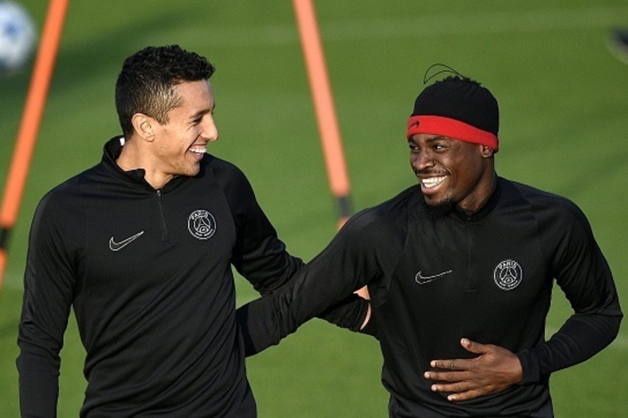 Paris Saint-Germain's Brazilian defender Marquinhos (L) jokes with Paris Saint-Germain's French defender Serge Aurier during a training session in Saint-Germain-en-Laye, west of Paris, on December 7, 2015 on the eve of the UEFA Champions League group A fo