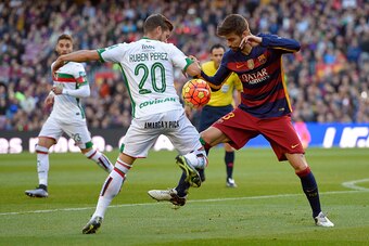 Barcelona's defender Gerard Pique (R) vies with Granada's midfielder Ruben Perez (L) during the Spanish league football match FC Barcelona vs Granada CF at the Camp Nou stadium in Barcelona on January 9, 2016.   AFP PHOTO / LLUIS GENE / AFP / LLUIS GENE  