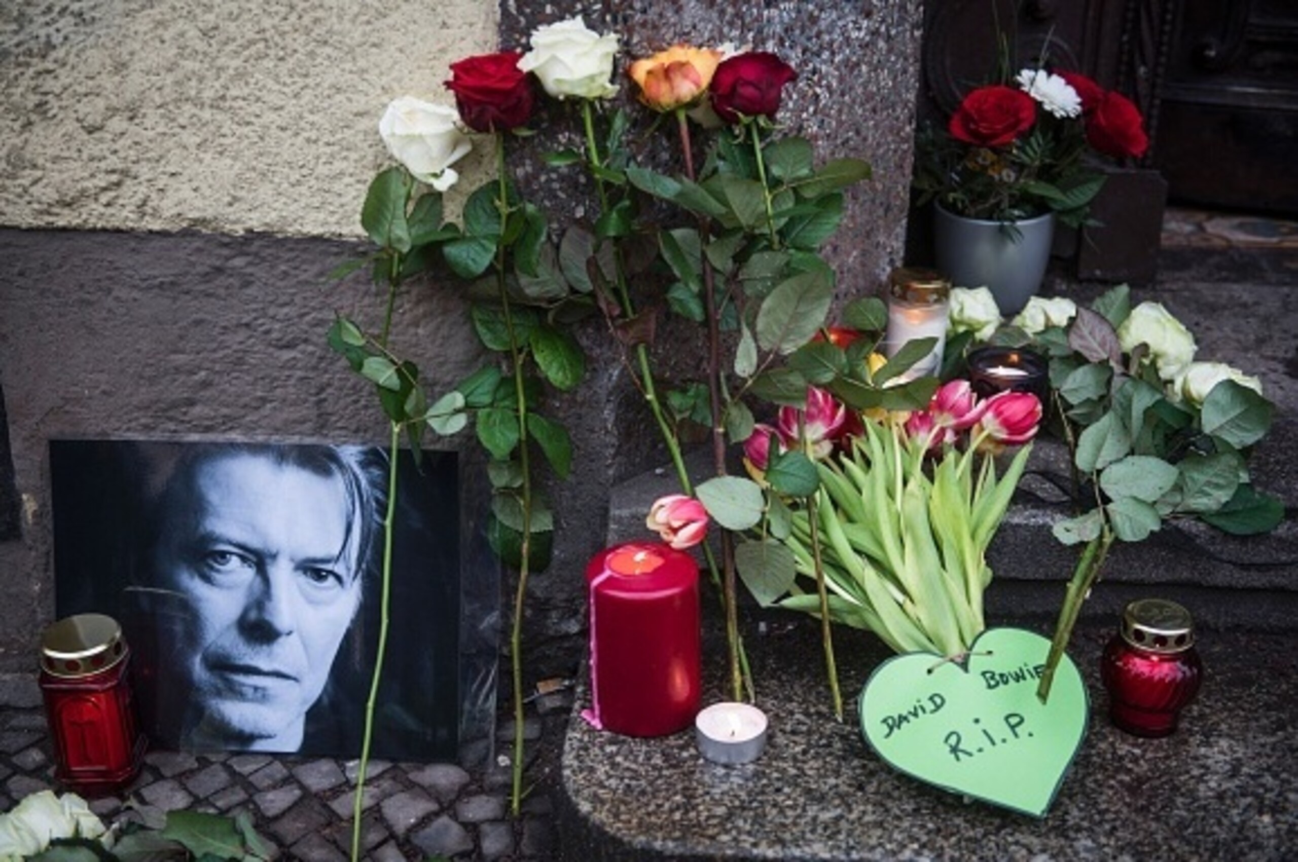 Tributes to British rock legend David Bowie are seen outside his former home in Berlin's  Hauptstrasse 155 on January 11, 2016.
British rock music legend David Bowie has died after a long battle with cancer, his official Twitter and Facebook accounts said