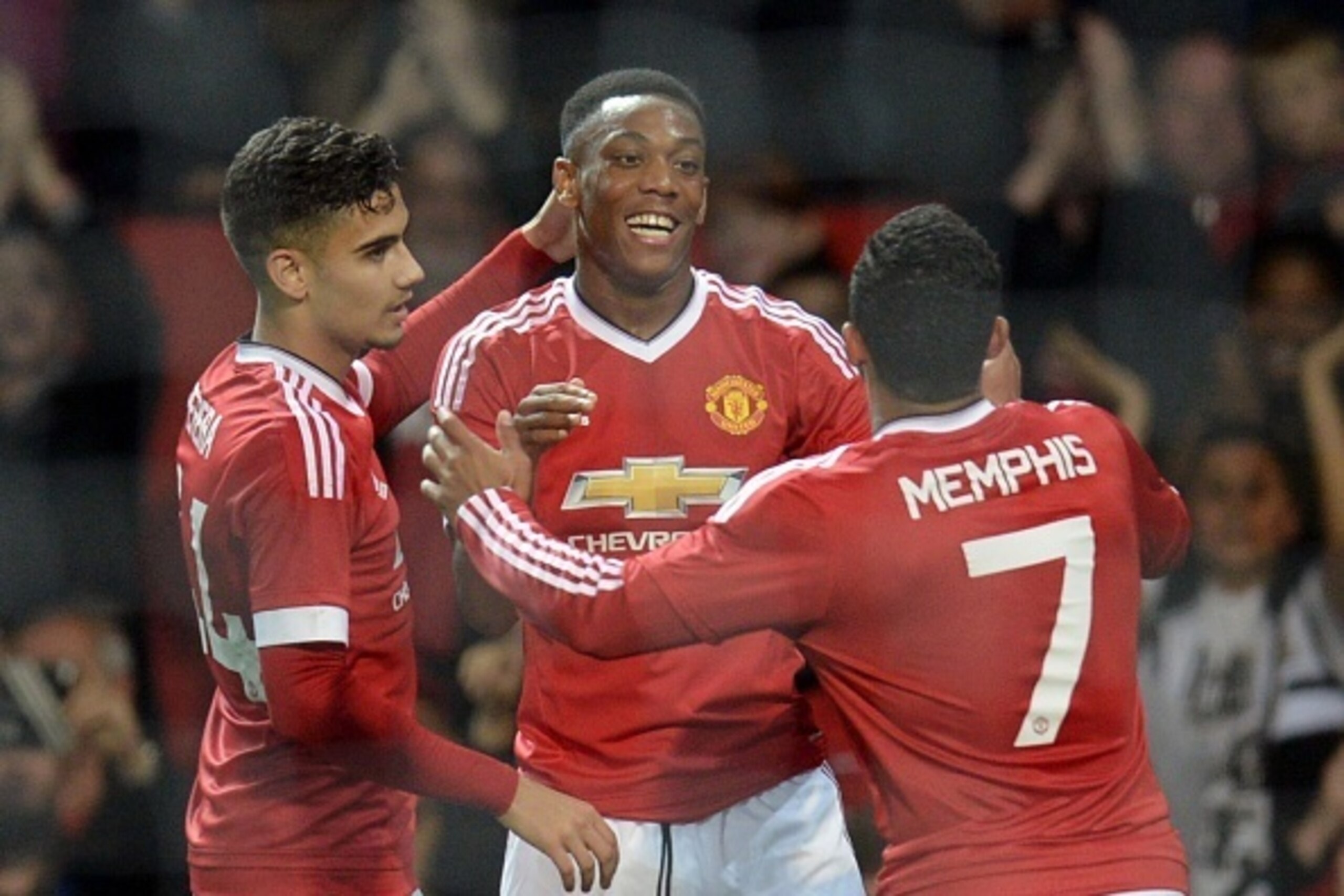 Manchester United's French midfielder Anthony Martial celebrates with Manchester United's Belgian midfielder Andreas Pereira (L) and Manchester United's Dutch midfielder Memphis Depay (R) after scoring their third goal during the English League Cup third 