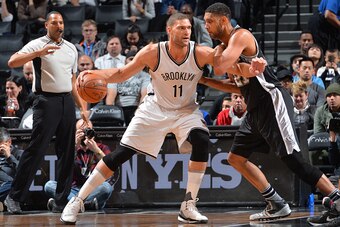 BROOKLYN, NY - JANUARY 11: Brook Lopez #11 of the Brooklyn Nets backs up to the basket against Tim Duncan #21 of the San Antonio Spurs on January 11, 2015 at Barclays Center in Brooklyn, New York. NOTE TO USER: User expressly acknowledges and agrees that,