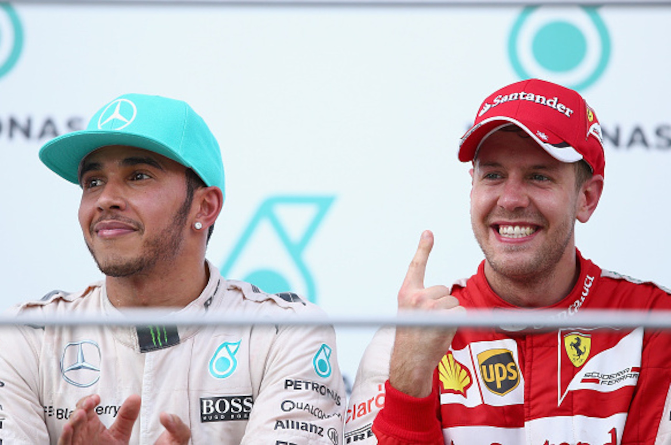 KUALA LUMPUR, MALAYSIA - MARCH 29:  Sebastian Vettel of Germany and Ferrari celebrates on the podium next to Lewis Hamilton of Great Britain and Mercedes GP after winning the Malaysia Formula One Grand Prix at Sepang Circuit on March 29, 2015 in Kuala Lum