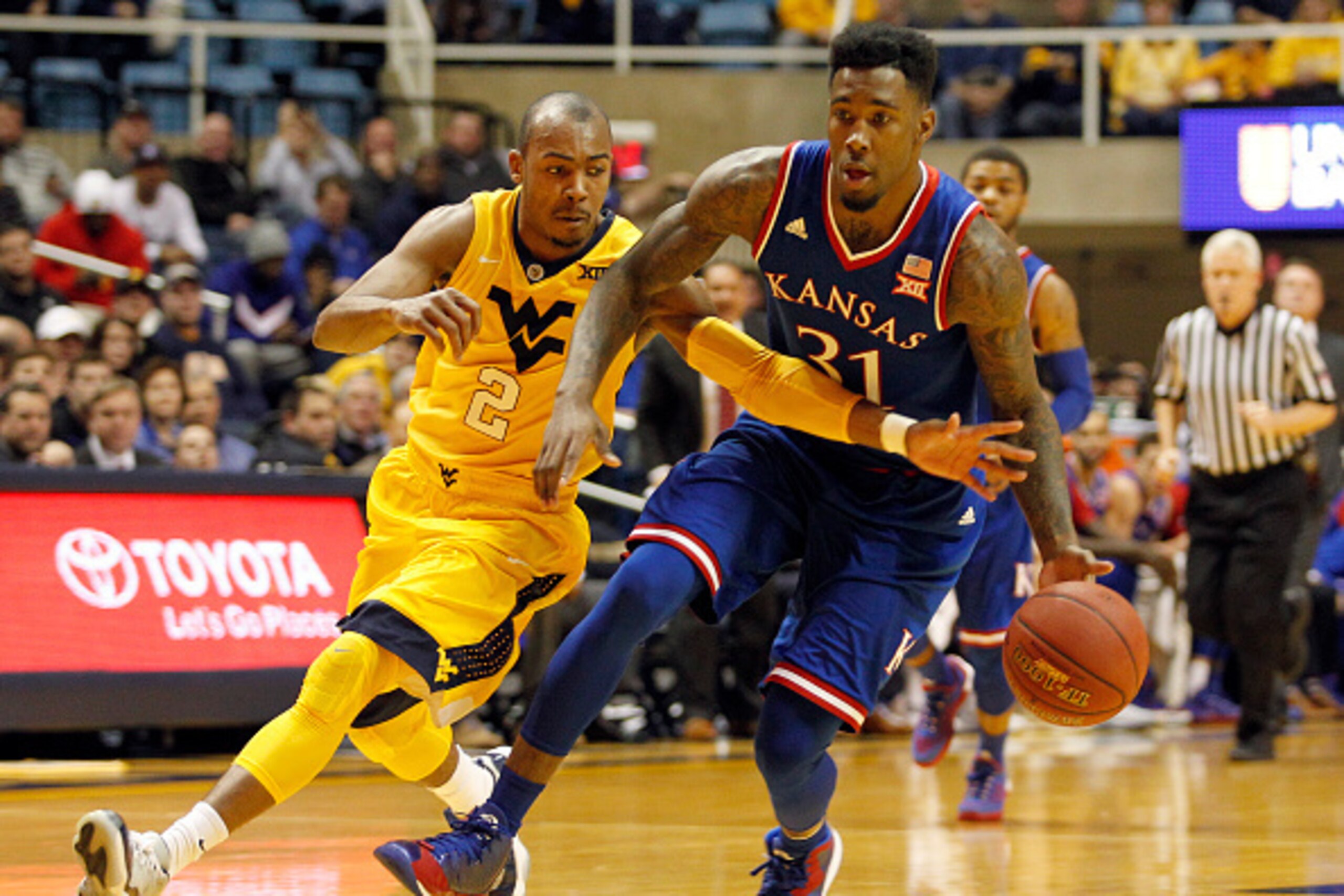 MORGANTOWN, WV - JANUARY 12:  Jamari Traylor #31 of the Kansas Jayhawks brings the ball down court against Jevon Carter #2 of the West Virginia Mountaineers during the game at the WVU Coliseum on January 12, 2016 in Morgantown, West Virginia.  (Photo by J