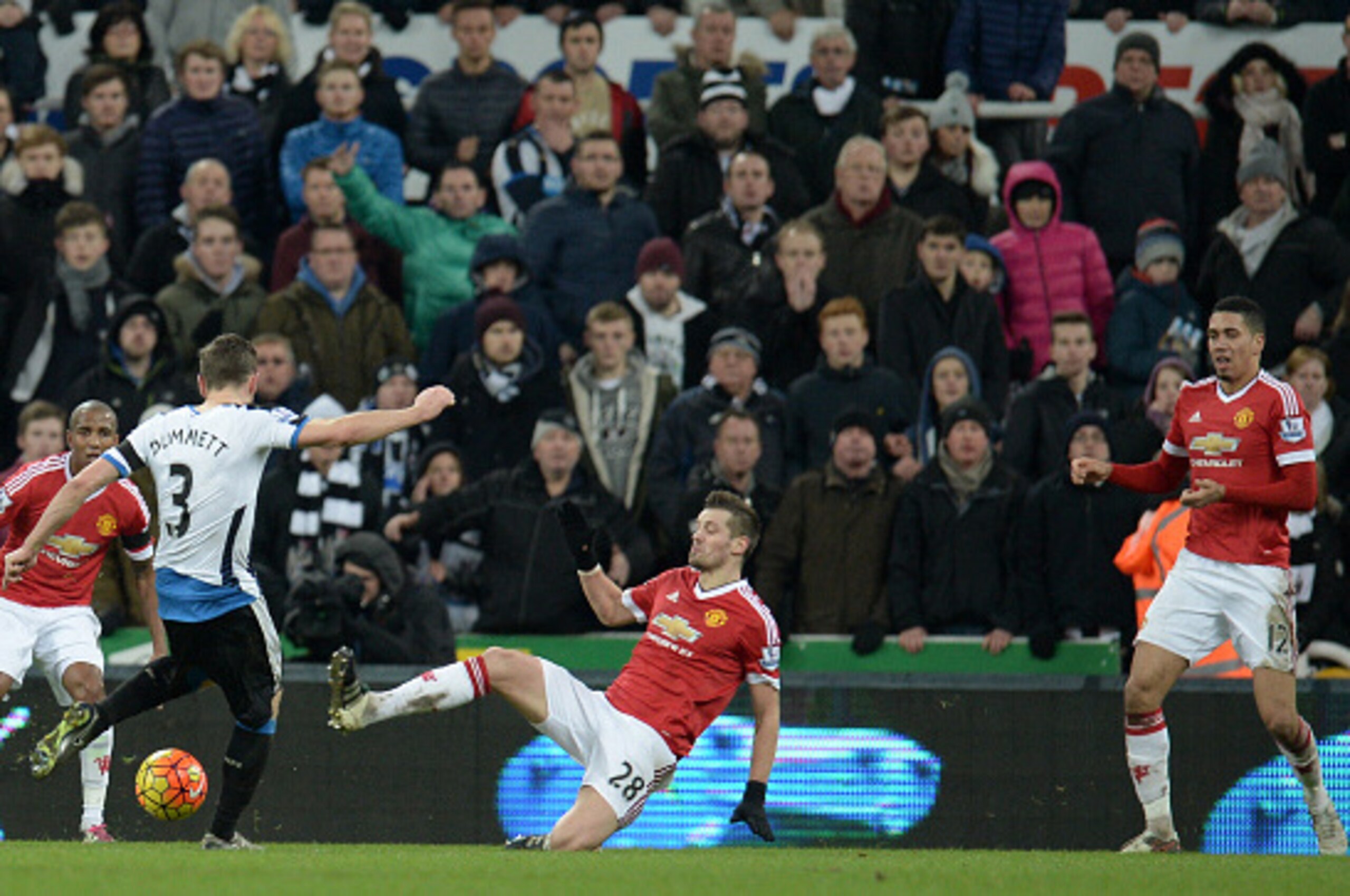 Newcastle United's Welsh defender Paul Dummett (2nd L) prepares to hit his shot which deflects off Manchester United's English defender Chris Smalling (R) for Newcastle's third goal during the English Premier League football match between Newcastle United