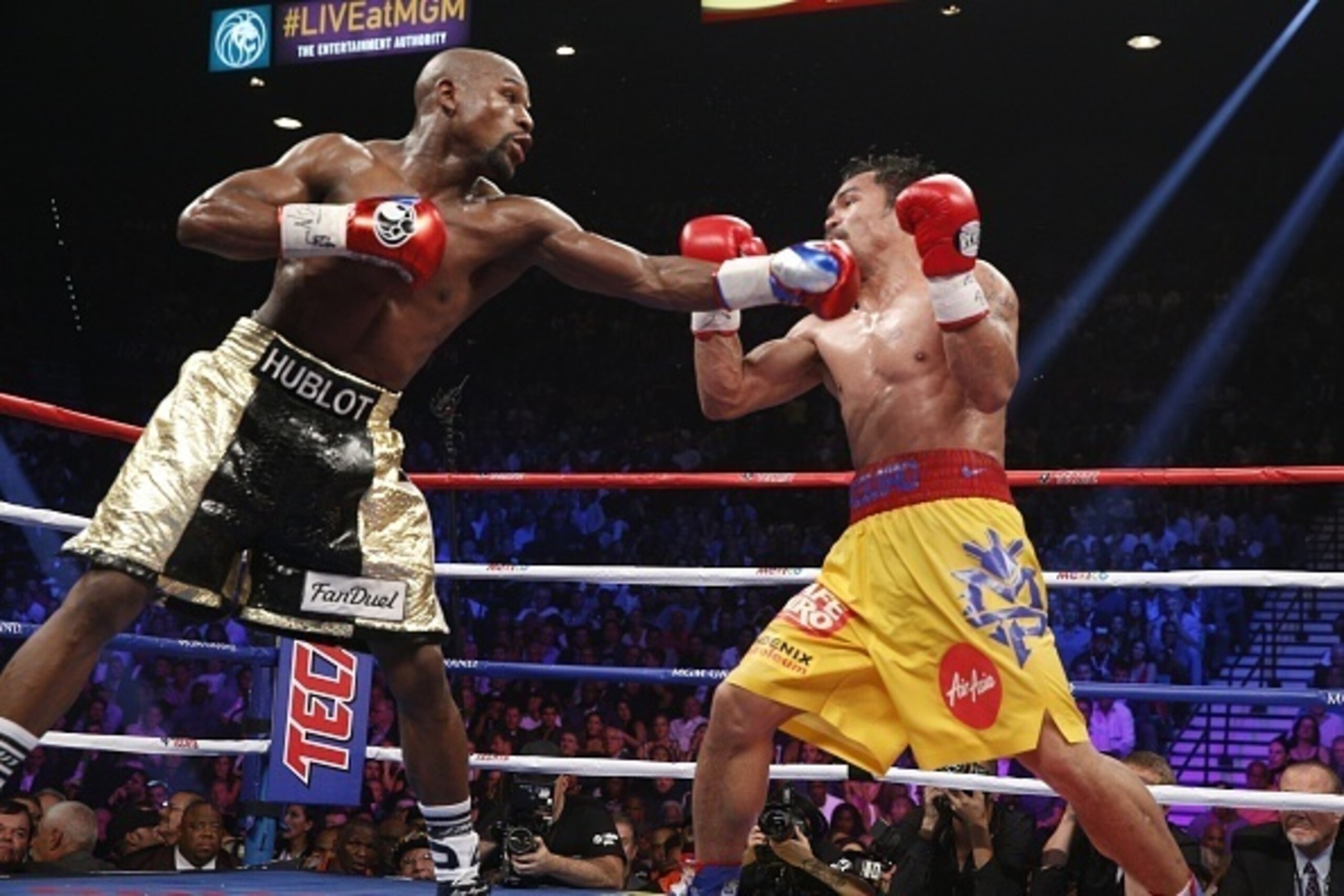 Floyd Mayweather Jr. exchange punches with Manny Pacquiao during their welterweight unification championship bout, May 2, 2015 at MGM Grand Garden Arena in Las Vegas, Nevada.  Mayweather defeated Pacquiao by unanimous decision.  AFP PHOTO / JOHN GURZINKSI