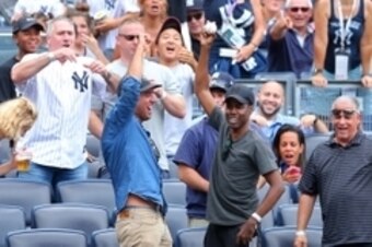 Aug 21, 2014; Bronx, NY, USA; Actor and comedian Chris Rock (center) holds up a foul ball he recovered during the seventh inning of a game between the New York Yankees and the Houston Astros at Yankee Stadium. The Yankees defeated the Astros 3-0. Mandator