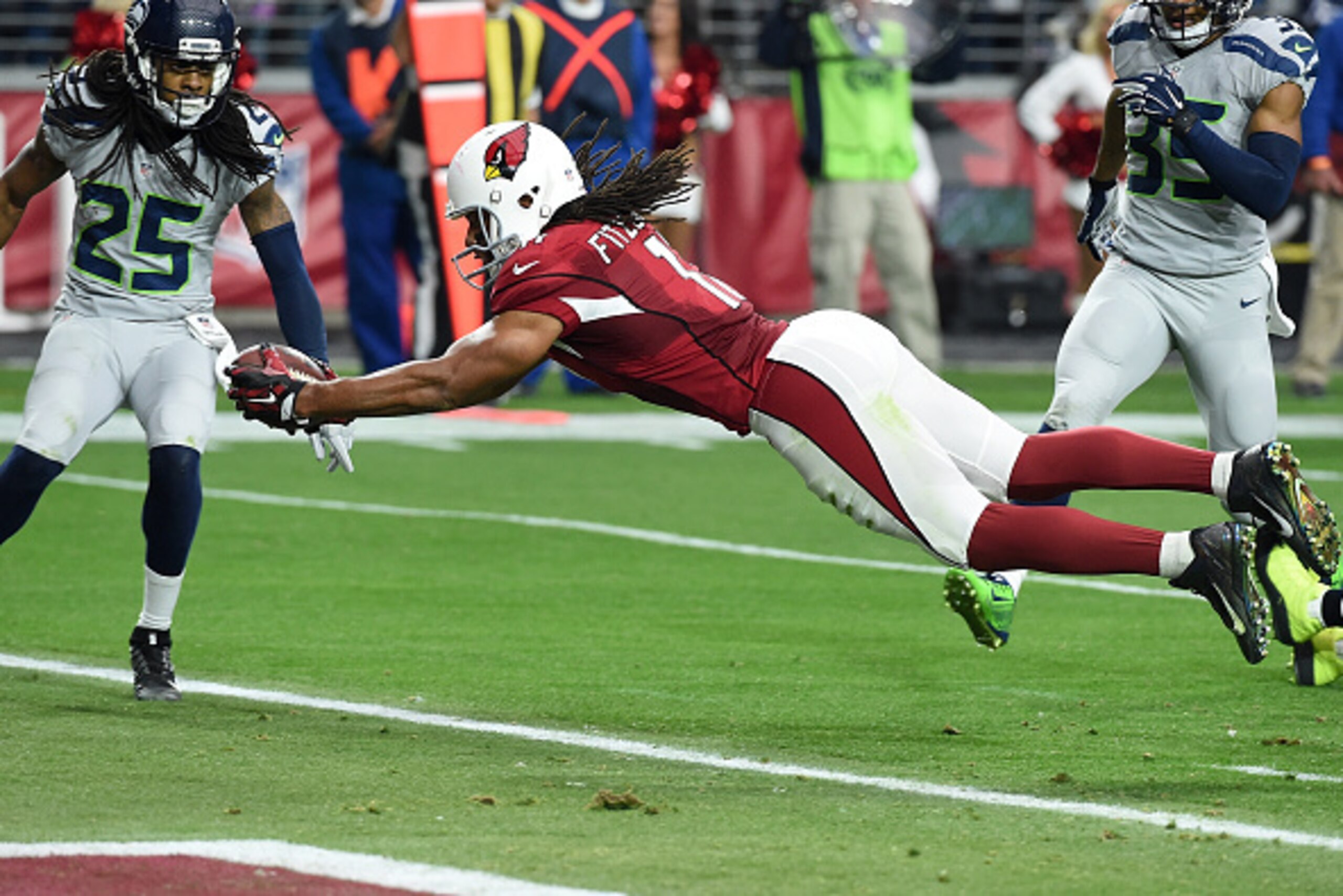 GLENDALE, AZ - JANUARY 03:  Wide receiver Larry Fitzgerald #11 of the Arizona Cardinals dives into the endzone to score a 17 yard touchdown against the Seattle Seahawks in the second quarter of the NFL game at University of Phoenix Stadium on January 3, 2