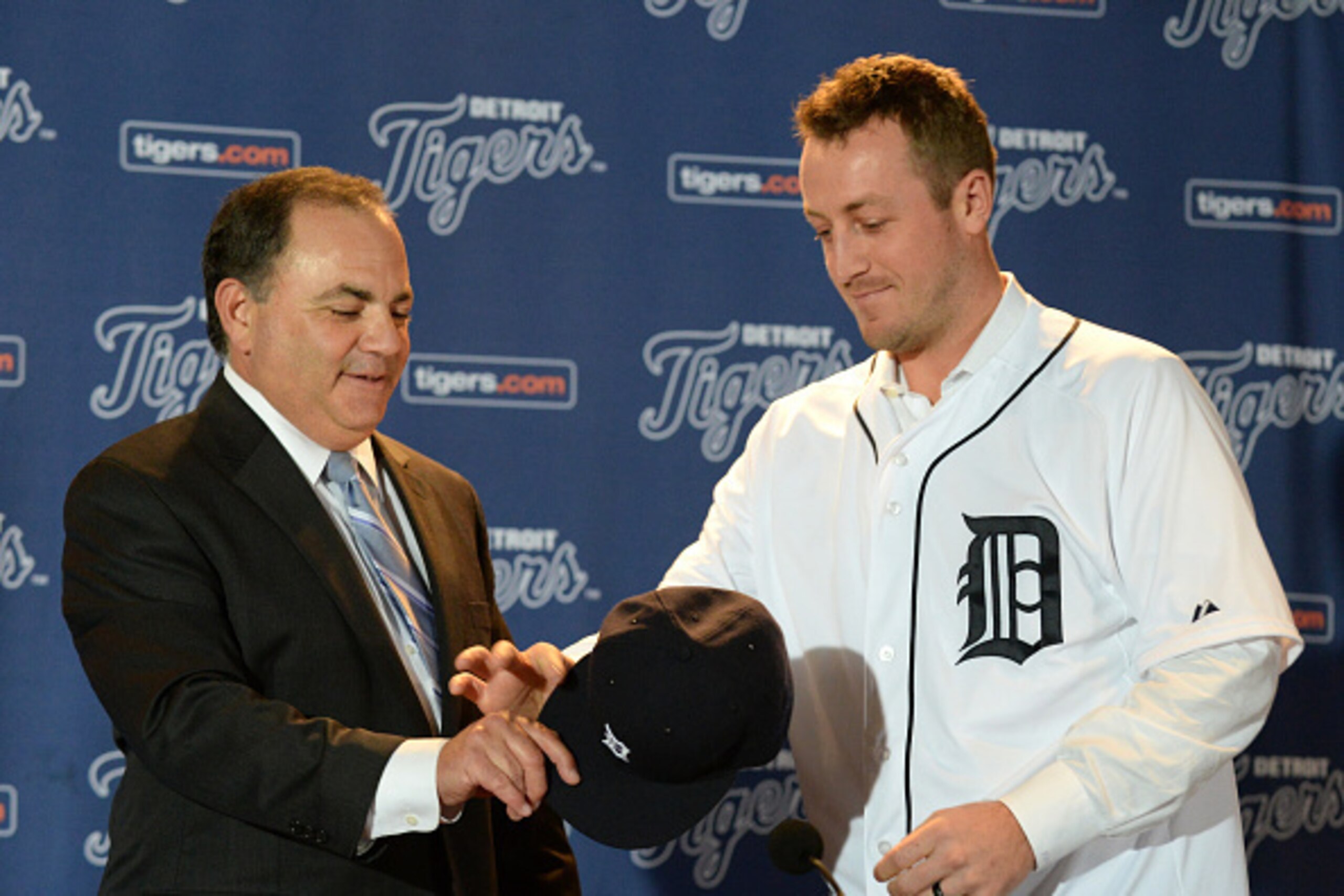 DETROIT, MI - NOVEMBER 30:  Detroit Tigers Executive Vice President of Baseball Operations and General Manager Al Avila hands a baseball hat to new Tigers pitcher Jordan Zimmermann #27 during the press conference to announce his contract signing at Comeri