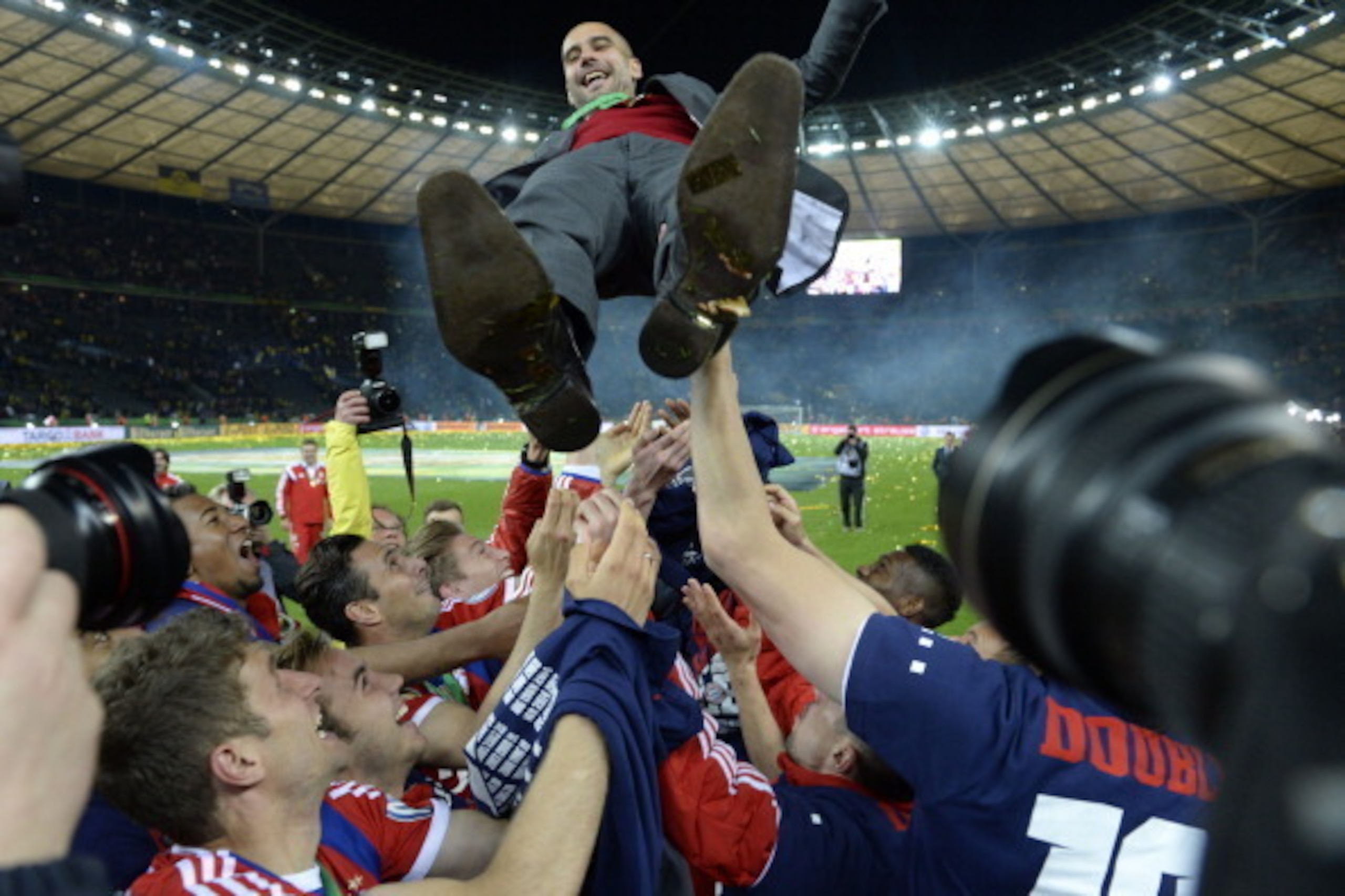 Bayern Munich's Spanish head coach Pep Guardiola (top) is thrown in the air by his players as they celebrate winning the DFB German Cup final football match BVB Borussia Dortmund vs Bayern Munich at the Olympic Stadium in Berlin on May 17, 2014.  
AFP PHO