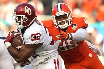 MIAMI GARDENS, FL - DECEMBER 31:  Samaje Perine #32 of the Oklahoma Sooners carries the ball as Kevin Dodd #98 of the Clemson Tigers attempts to tackle him in the first quarter during the 2015 Capital One Orange Bowl at Sun Life Stadium on December 31, 20