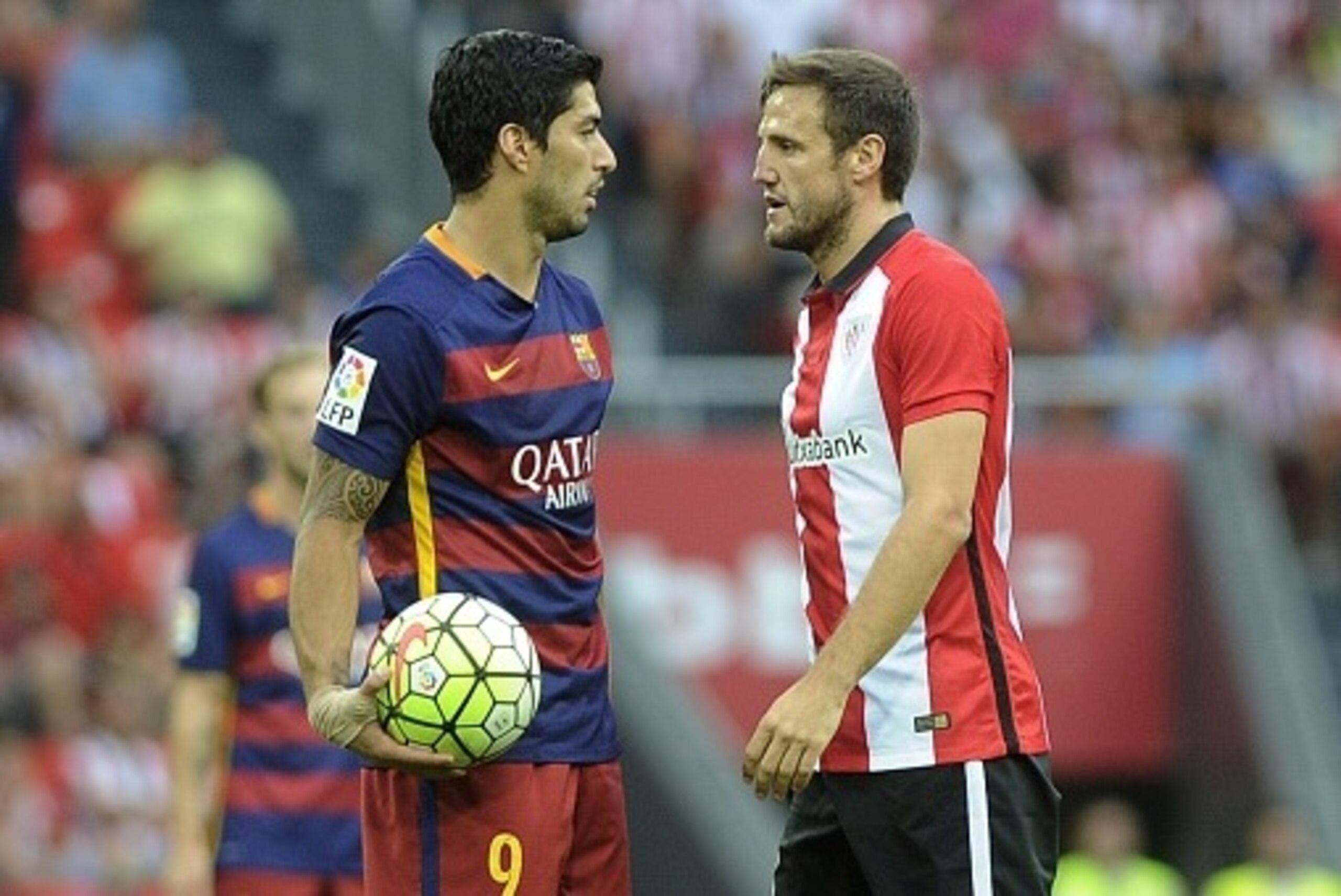 Barcelona's Uruguayan forward Luis Suarez (L) and Athletic Bilbao's midfielder Carlos Gurpegi (R) react during the Spanish league football match Athletic Club Bilbao vs FC Barcelona at the San Mames stadium in Bilbao on August 23, 2015.  AFP PHOTO/ ANDER 