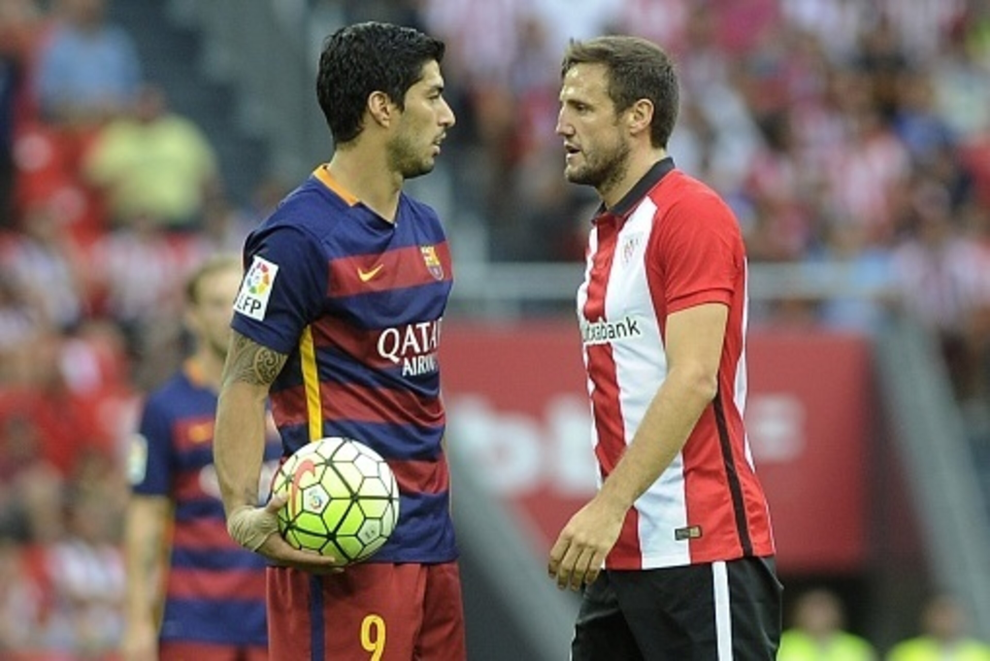 Barcelona's Uruguayan forward Luis Suarez (L) and Athletic Bilbao's midfielder Carlos Gurpegi (R) react during the Spanish league football match Athletic Club Bilbao vs FC Barcelona at the San Mames stadium in Bilbao on August 23, 2015.  AFP PHOTO/ ANDER 