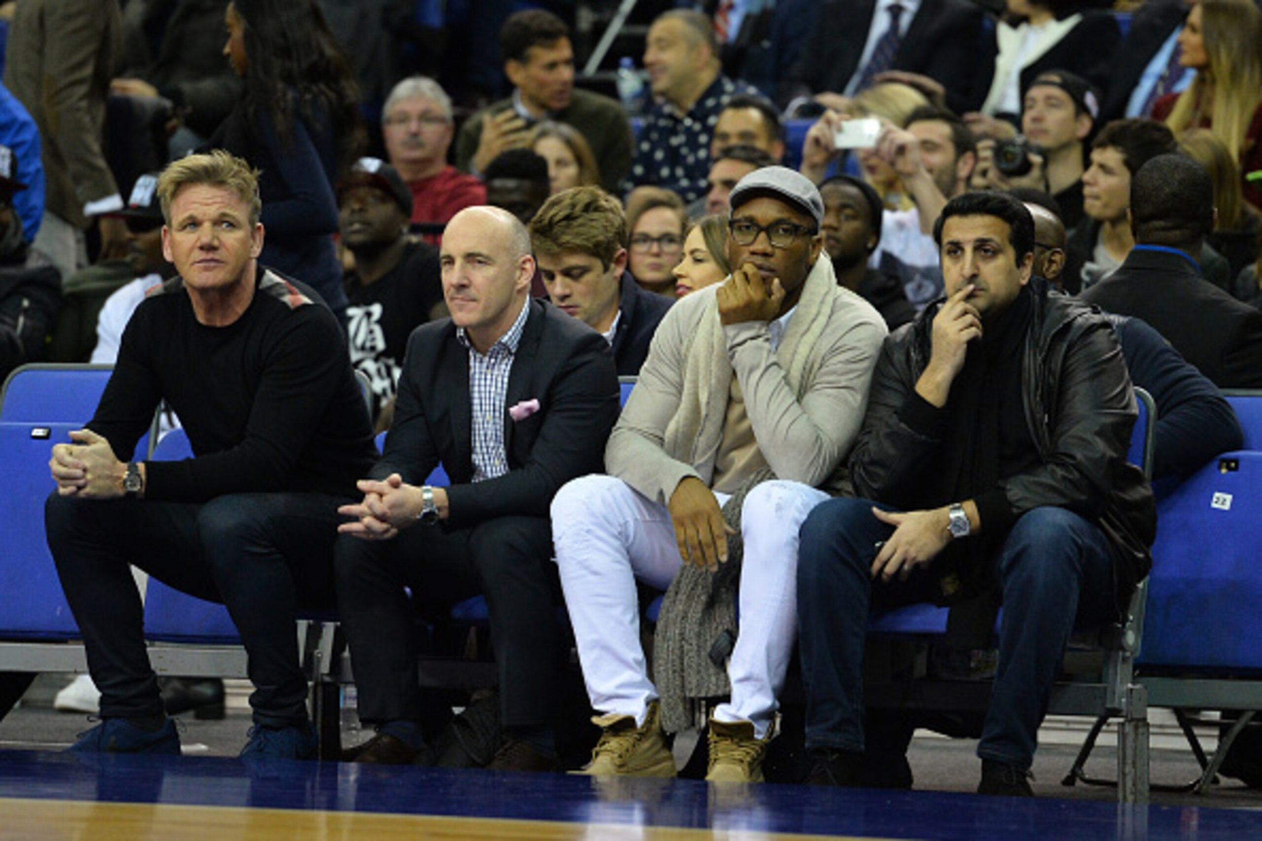 British chef Gordon Ramsey (L) and former Chelsea forward Didier Drogba (2R) watch the NBA Global Game London 2016 basketball match between Orlando Magic and Toronto Raptors at the O2 Arena in London on January 14, 2016. AFP PHOTO / GLYN KIRK / AFP / GLYN