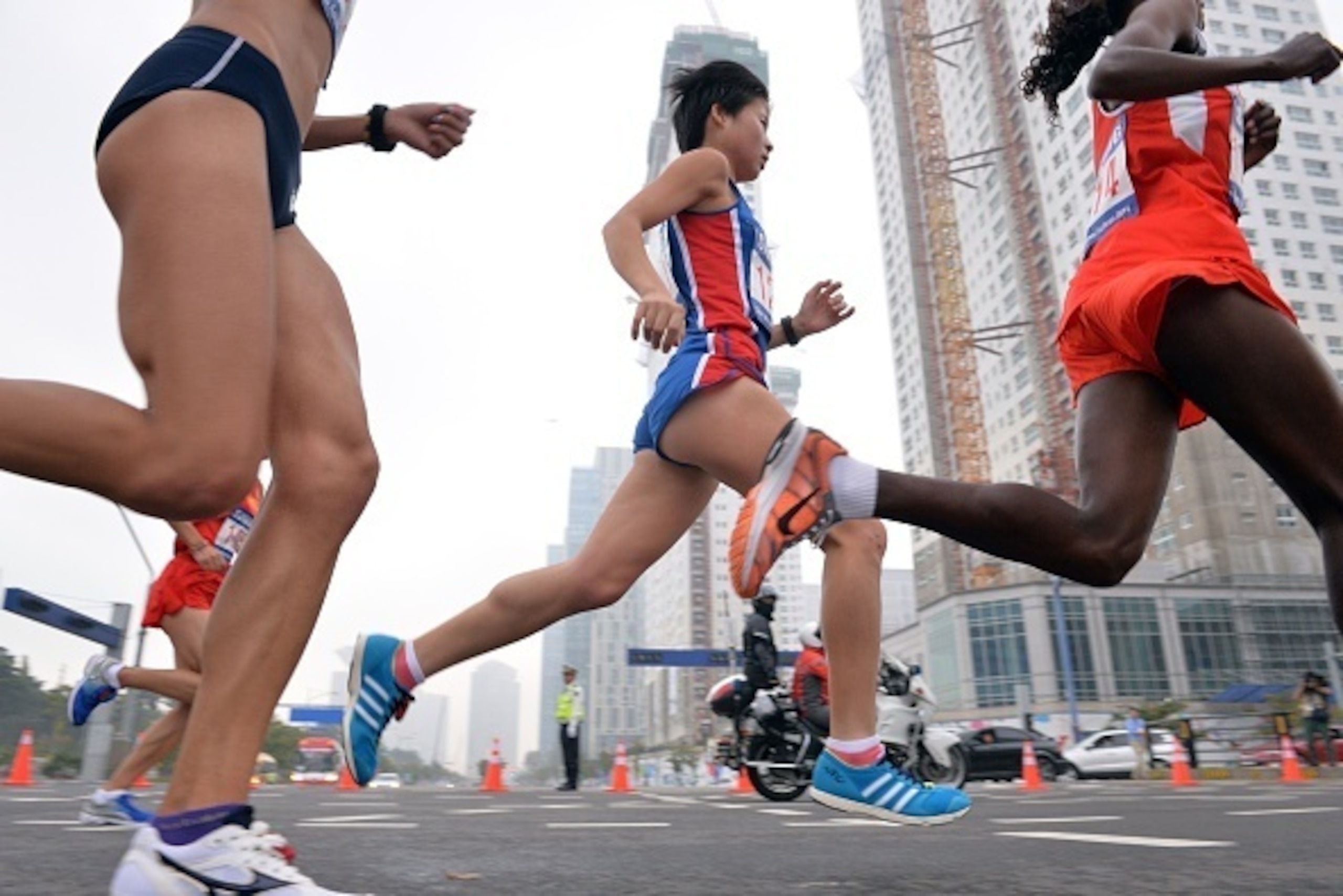 North Korea's Kim Hyegyong (C) runs with the pack in the early stages of the women's marathon event during the 17th Asian Games in Incheon on October 2, 2014.    AFP PHOTO / BAY ISMOYO        (Photo credit should read BAY ISMOYO/AFP/Getty Images)