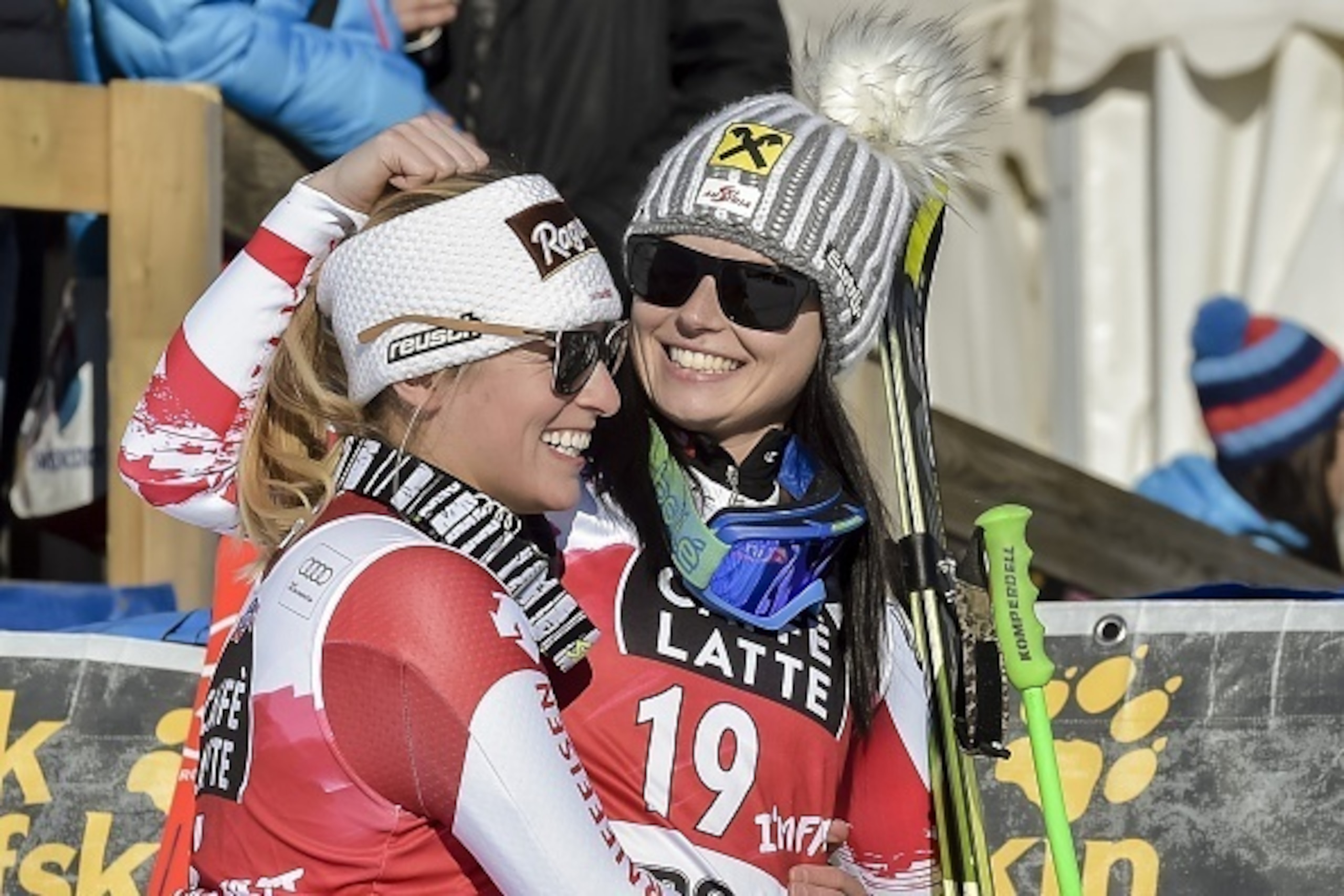 Winner Lara Gut of Switzerland (L) hugs sencond placed Anna Fenninger of Austria prior the Flowers ceremony during the FIS Alpine Ski World Cup women's downhill race in St. Moritz, on January 24, 2015. AFP PHOTO / GUENTER SCHIFFMANN        (Photo credit s