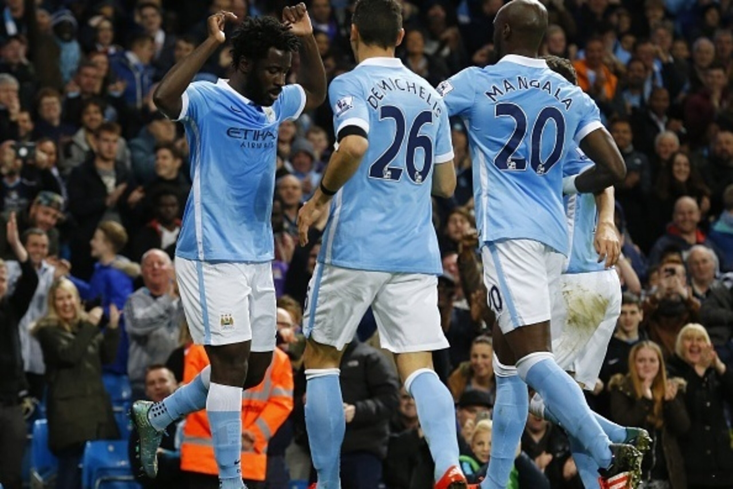 Manchester City's Ivorian striker Wilfried Bony (L) celebrates with teammates after scoring the opening goal during the English League Cup fourth round football match between Manchester City and Crystal Palace at The Etihad Stadium in Manchester, north we