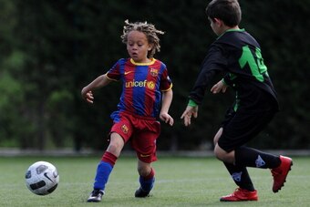 BARCELONA, SPAIN - MAY 15:  Eight-year-old Barcelona youth player Xavi Simons strikes the ball besides a Llongueras youth player on one of the pitches at the Joan Camper training ground on May 15, 2011 in Barcelona, Spain. Every weekend various teams of B
