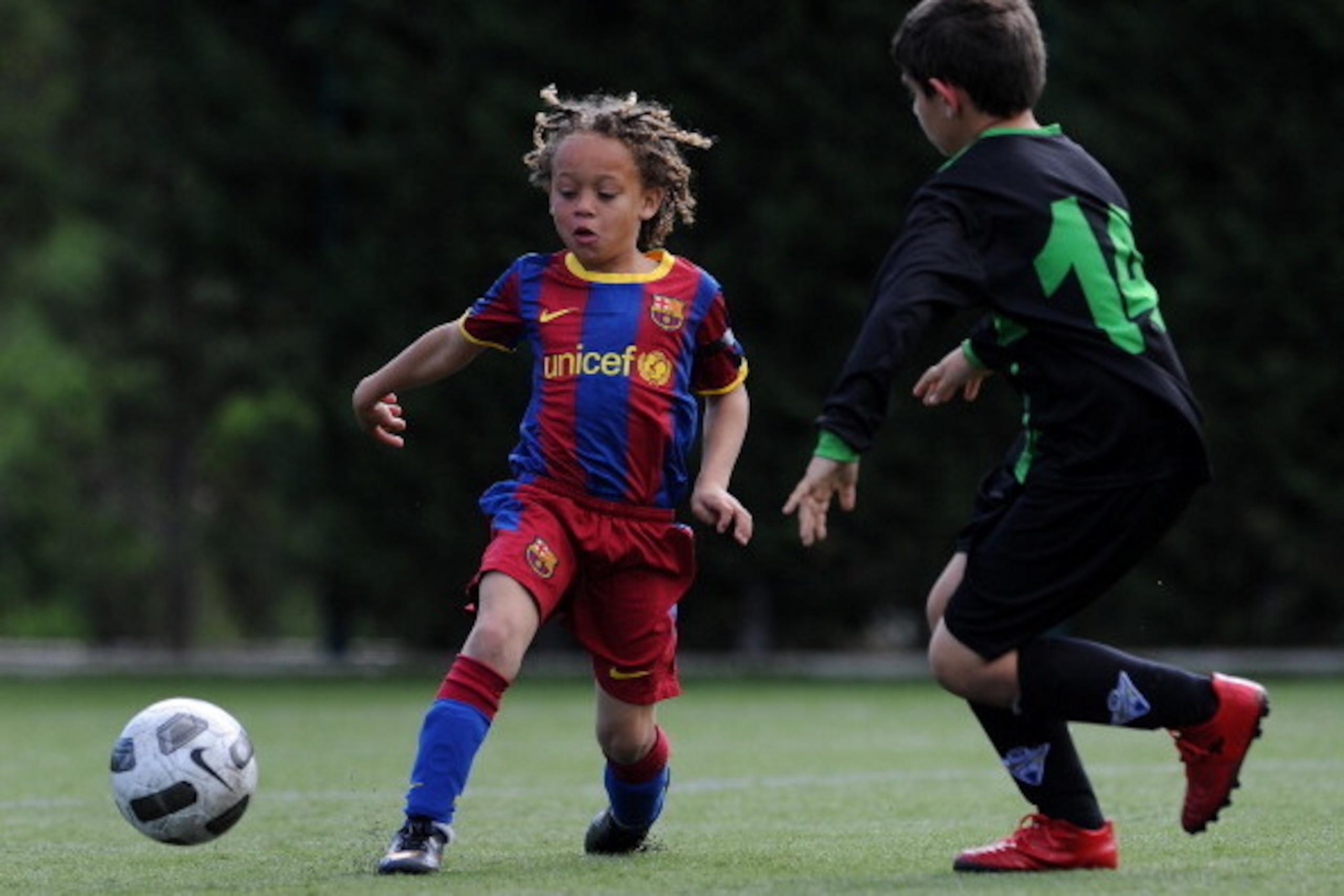 BARCELONA, SPAIN - MAY 15:  Eight-year-old Barcelona youth player Xavi Simons strikes the ball besides a Llongueras youth player on one of the pitches at the Joan Camper training ground on May 15, 2011 in Barcelona, Spain. Every weekend various teams of B